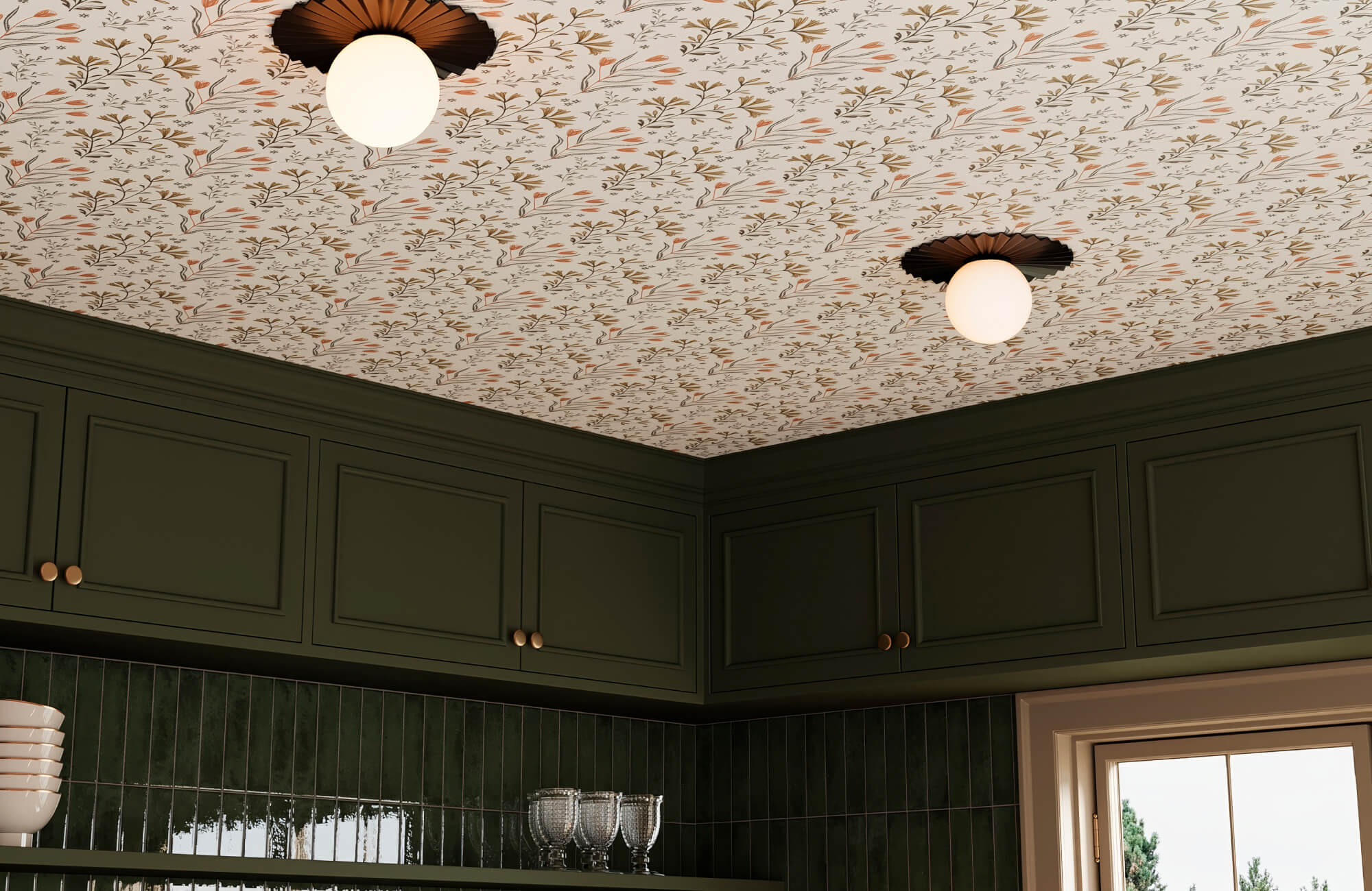Moody kitchen with deep olive cabinetry, glossy vertical green subway tile backsplash, and a floral botanical wallpapered ceiling with warm brass accents.