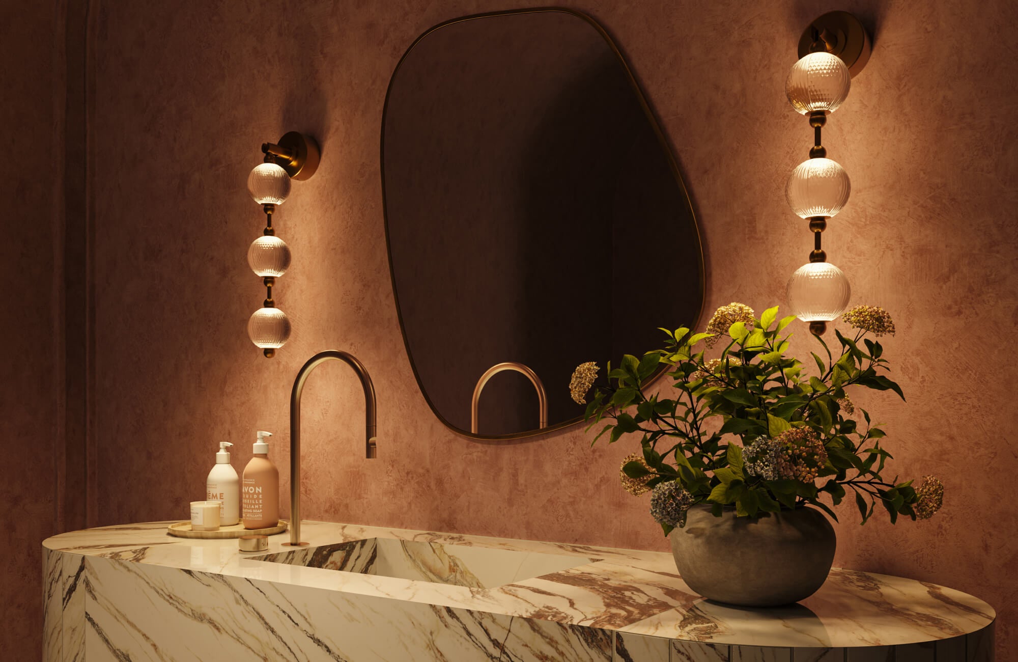 A stylish bathroom showcases a sculptural marble vanity with an integrated sink, warm textured walls, a softly lit organic-shaped mirror, globe sconces, and curated decor that elevates the bathroom into a refined, spa-inspired space.