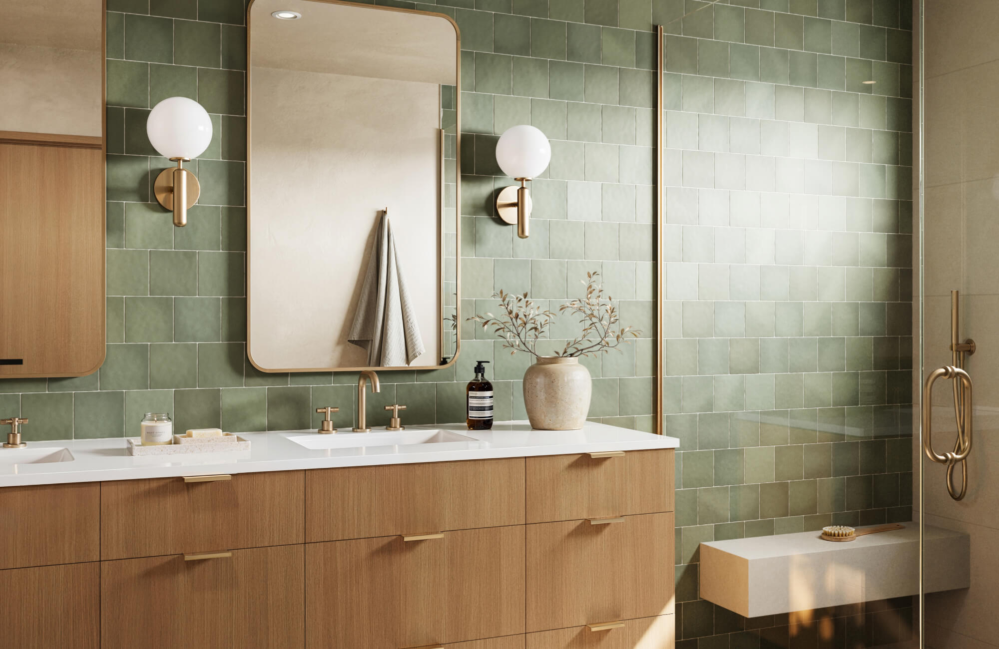 null Modern bathroom renovation featuring soft green glazed wall tiles, a warm wood double vanity with integrated sinks, brass fixtures, globe sconces, and a glass-enclosed shower that creates a calm, contemporary spa-like setting.