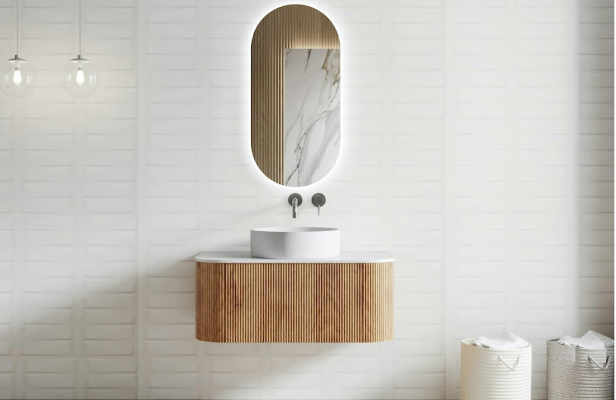 null Minimalist bathroom renovation featuring a floating fluted wood vanity, round vessel sink, integrated wall-mounted faucet, and softly backlit oval mirror set against clean white textured wall tiles for a serene, modern look.