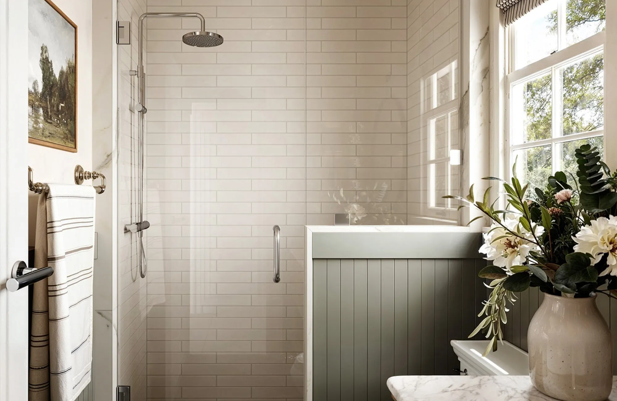 Walk-in shower with glossy white subway tiles and chrome fixtures beside a green half-wall panel.