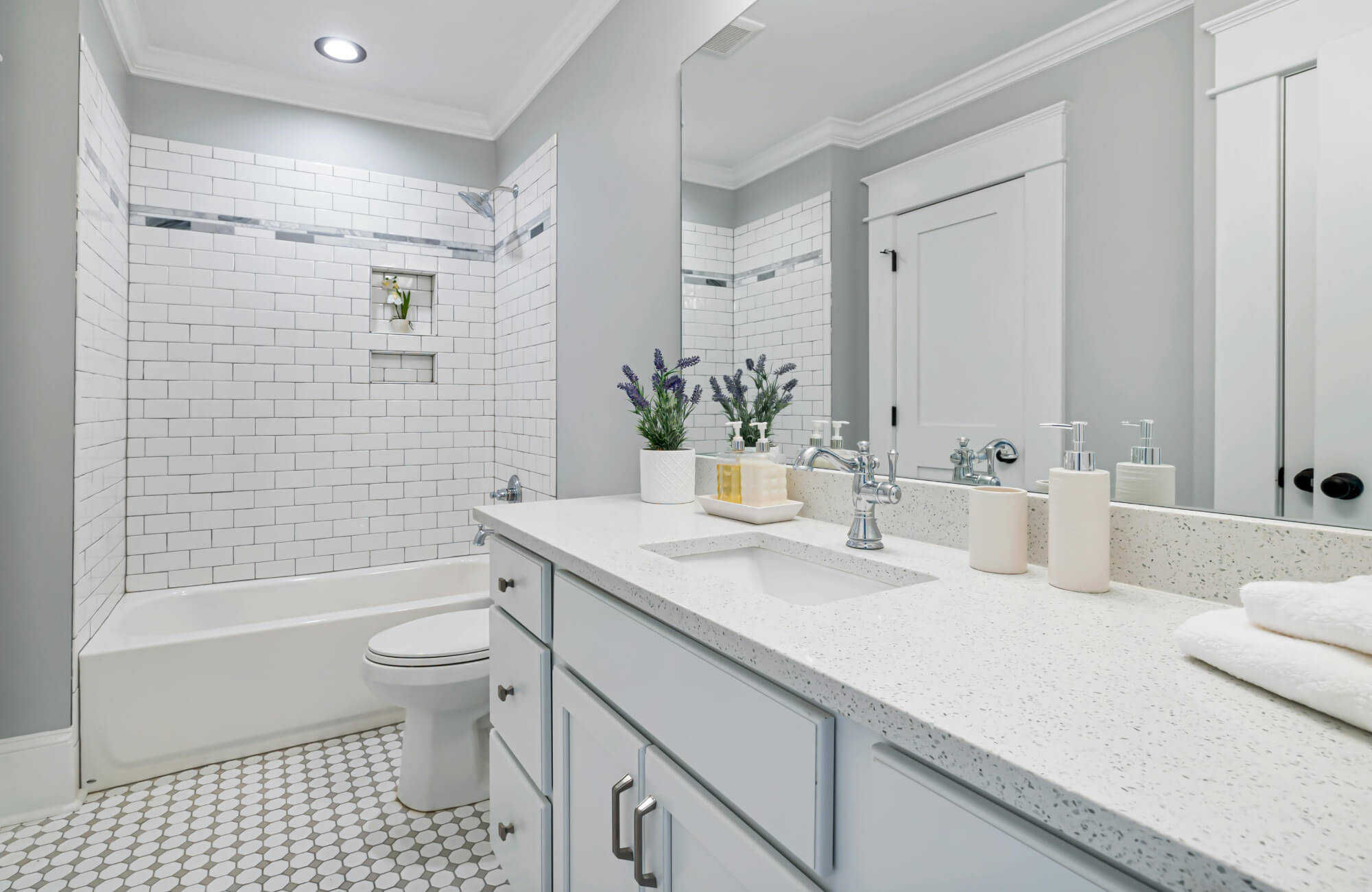 null Bathtub shower combo with classic white subway tiles, mosaic border, and recessed niche.