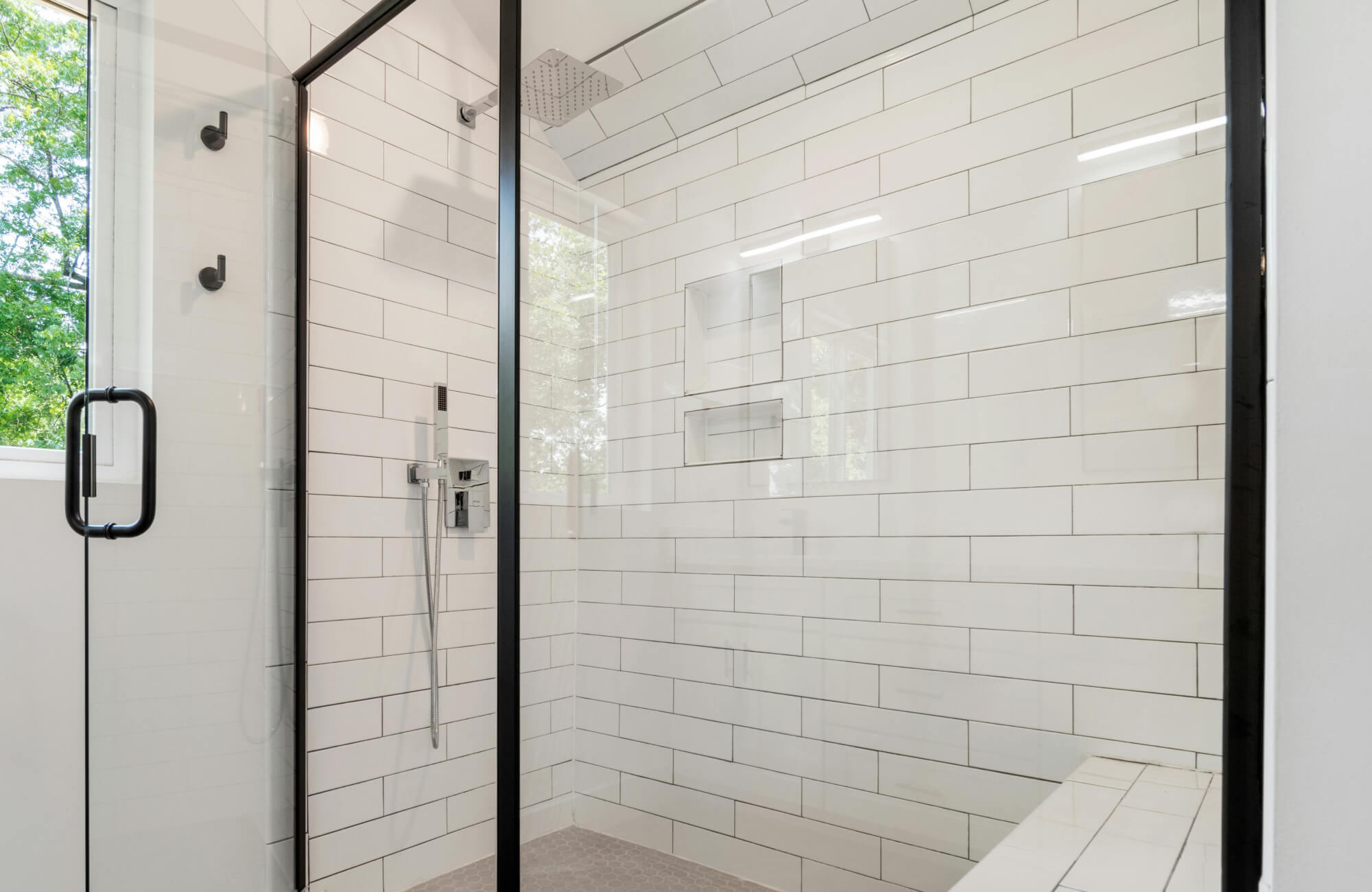 null Modern glass shower with white subway tiles in a stacked layout, accented by a black frame door and fixtures.