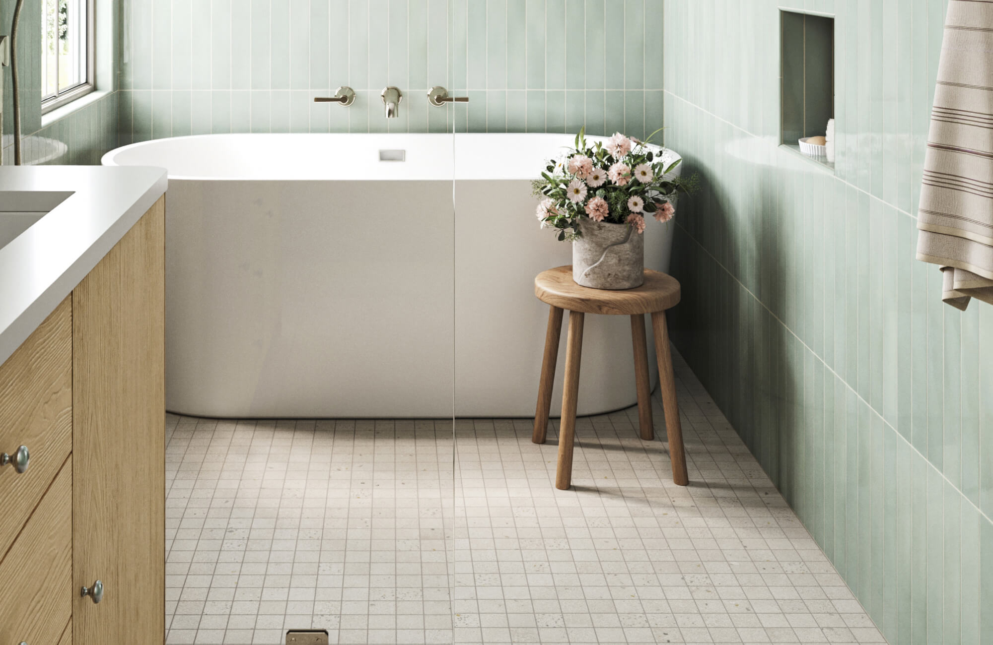 null Fresh and airy bathroom with soft green vertical wall tiles, a terrazzo like flooring, a freestanding white bathtub, and natural light enhanced by a simple pendant lamp for a serene spa-like ambiance.