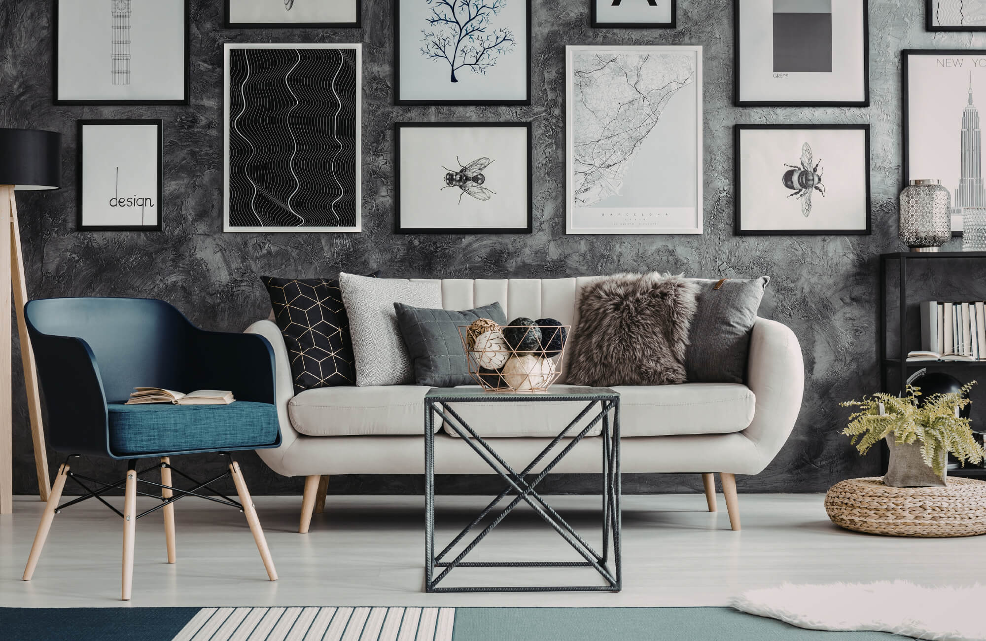 null Modern salon-style gallery wall above sofa with black frames, textured gray wall, and layered decorative accents.