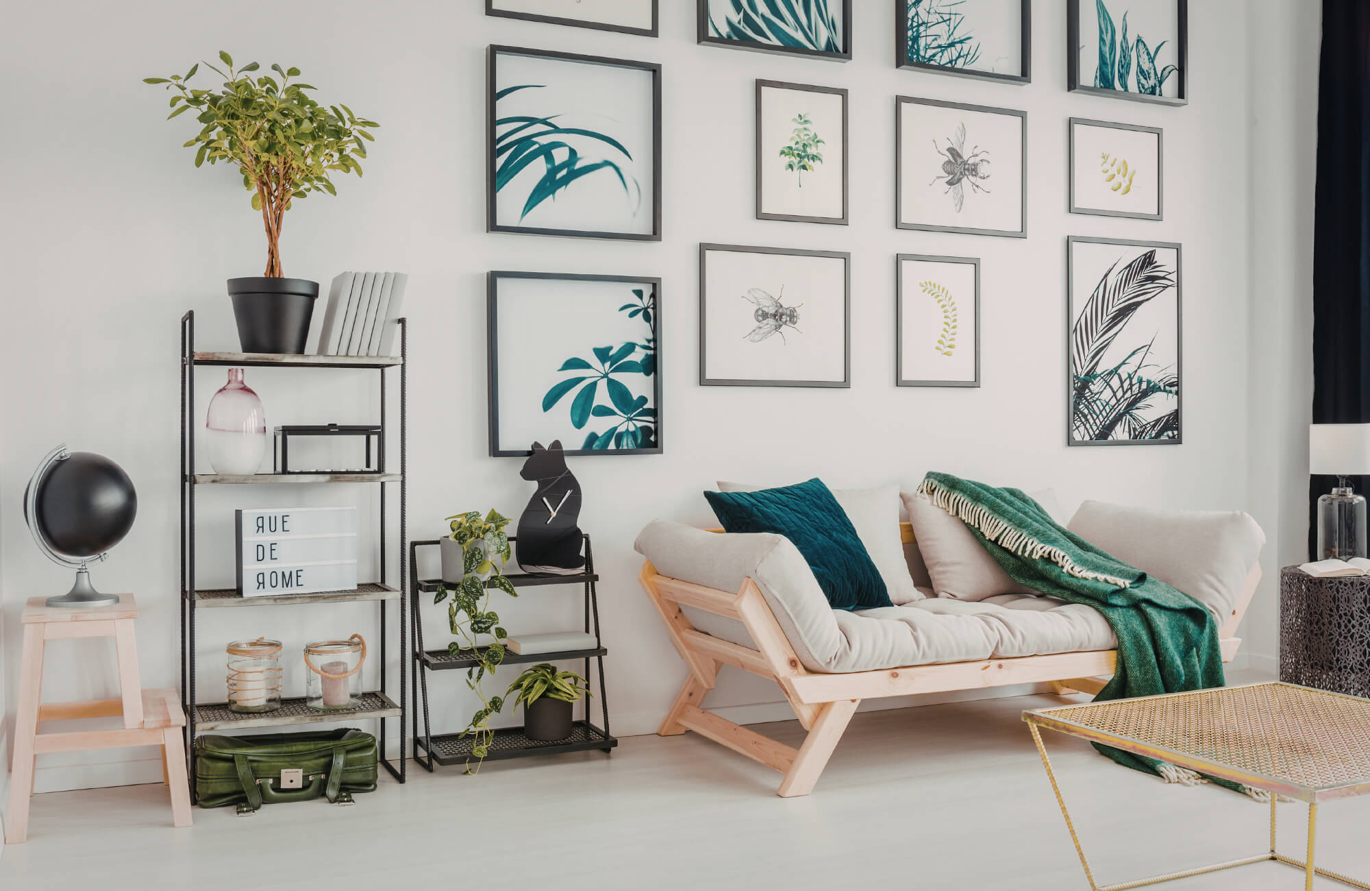 null Bright living space featuring botanical gallery wall in black frames above a minimalist wood daybed.