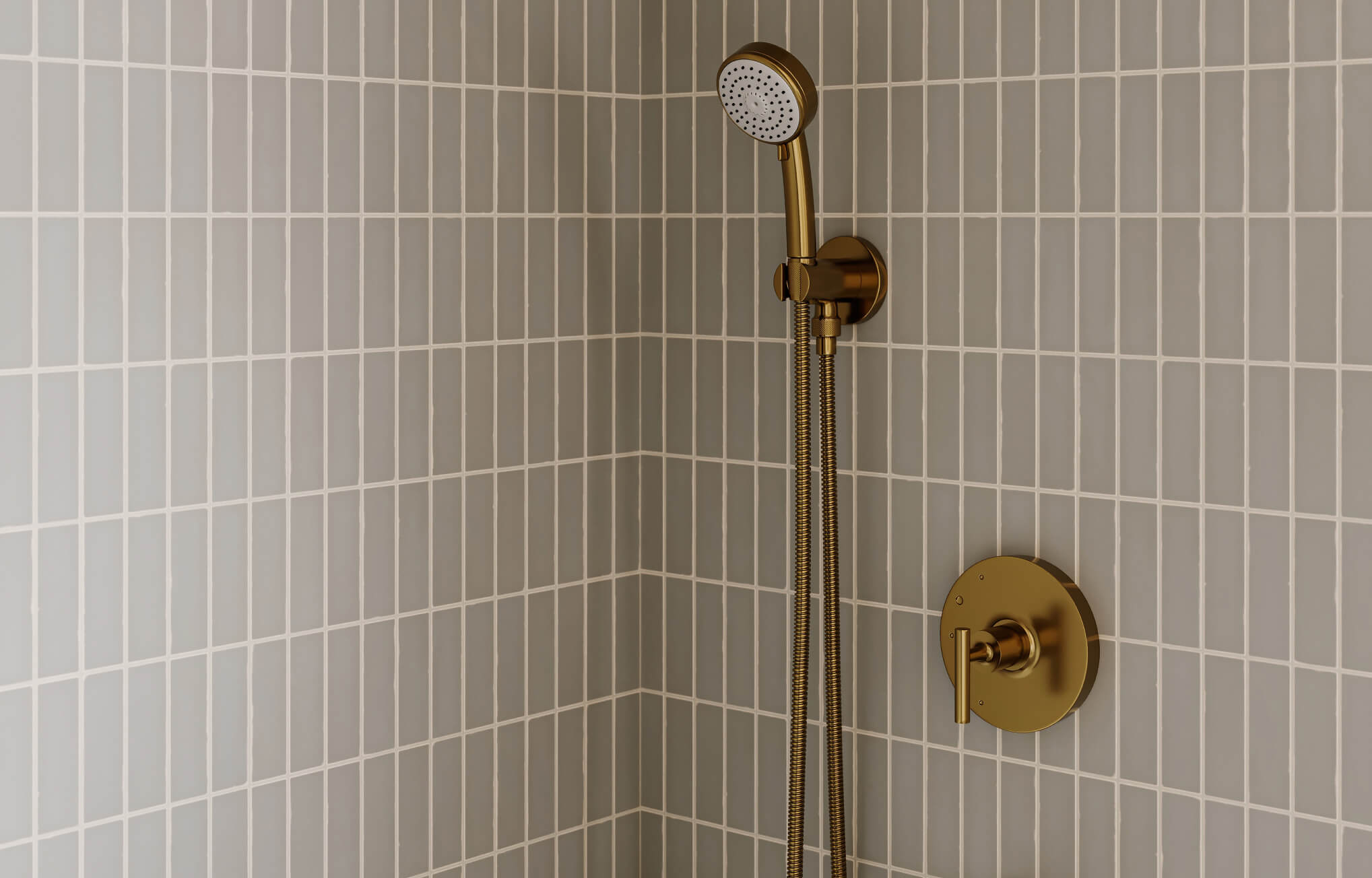 null Grey vertical stacked subway tiles highlight a shower wall, with bold brass fixtures adding contrast and sophistication.