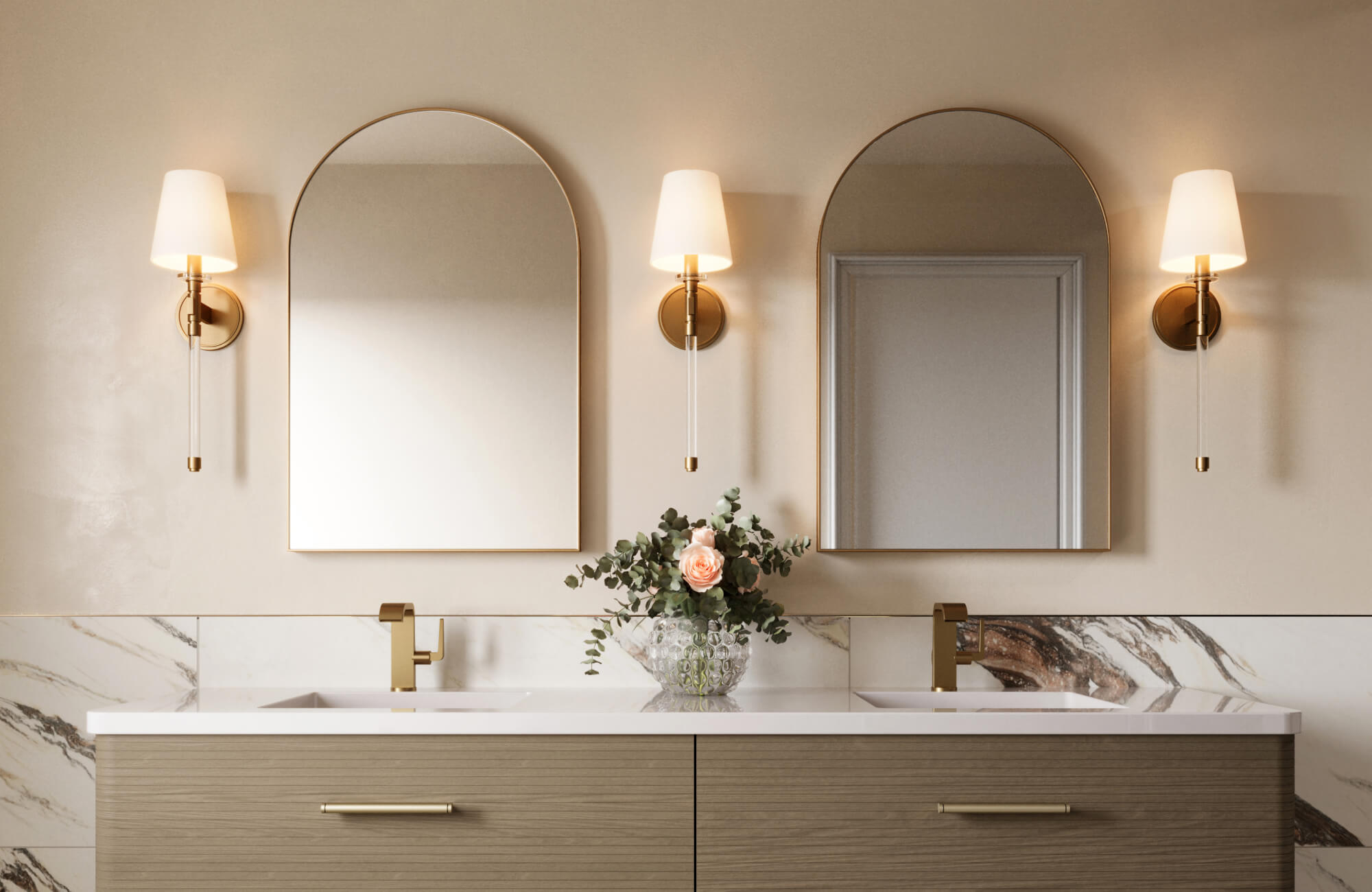 Bathroom with stylish mirror placement above double sinks, featuring brass sconces, arched mirrors, and floral centerpiece.
