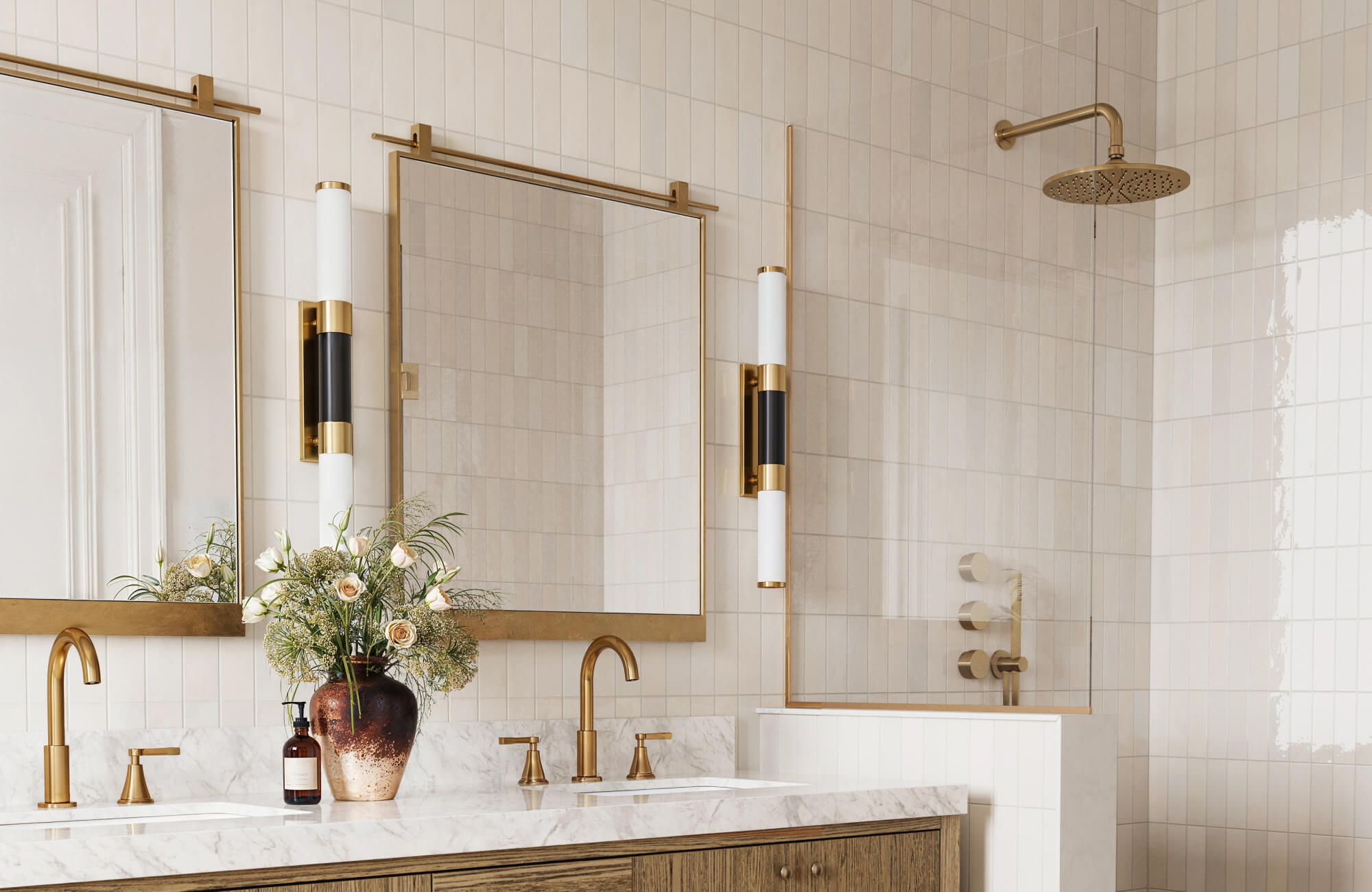 Contemporary bathroom with brass-framed mirrors and double vanity, showcasing ideal mirror placement and layered lighting design.