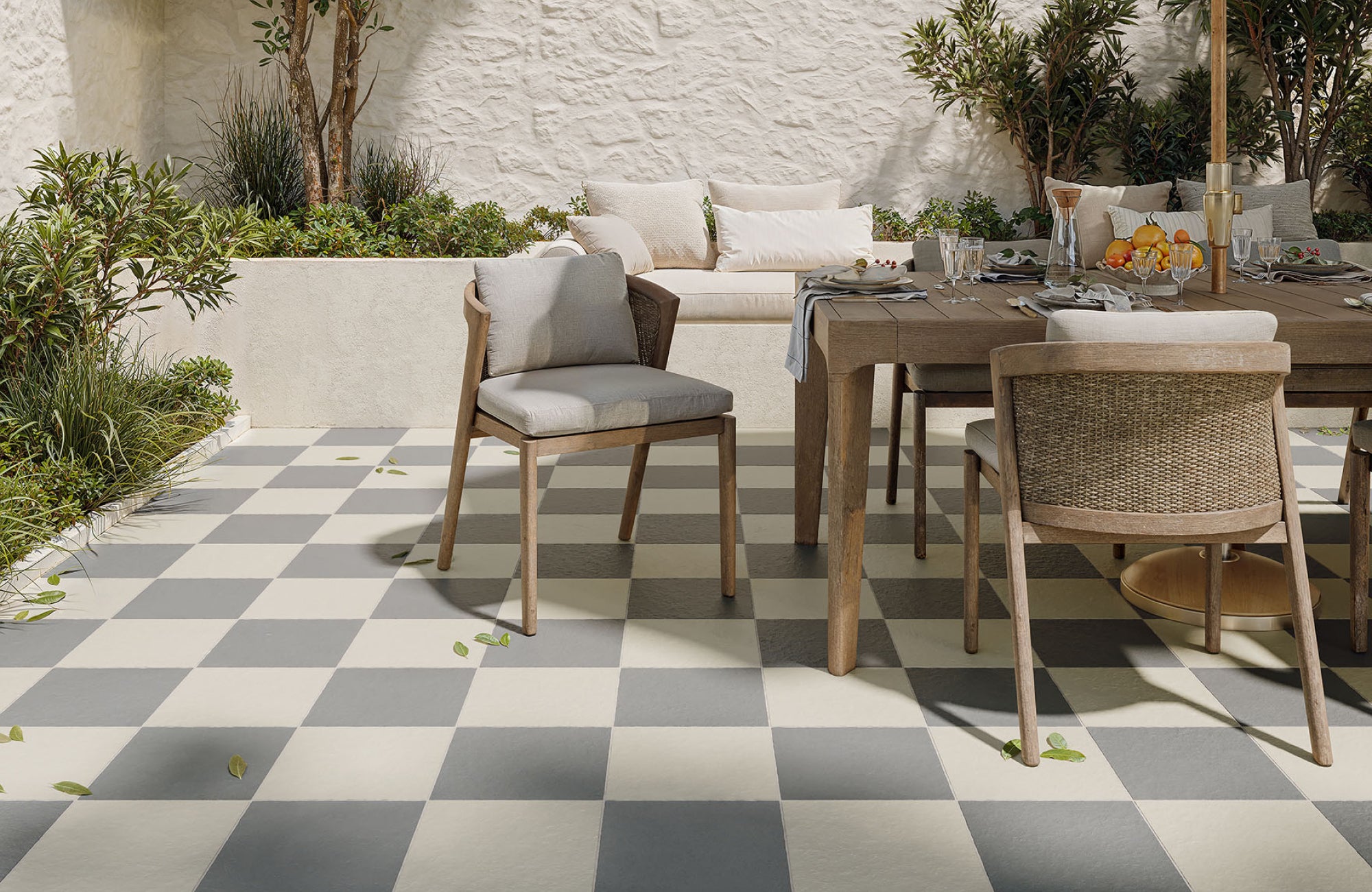 Outdoor dining area with warm checkerboard tile flooring in a soft cream and grey porcelain finish.