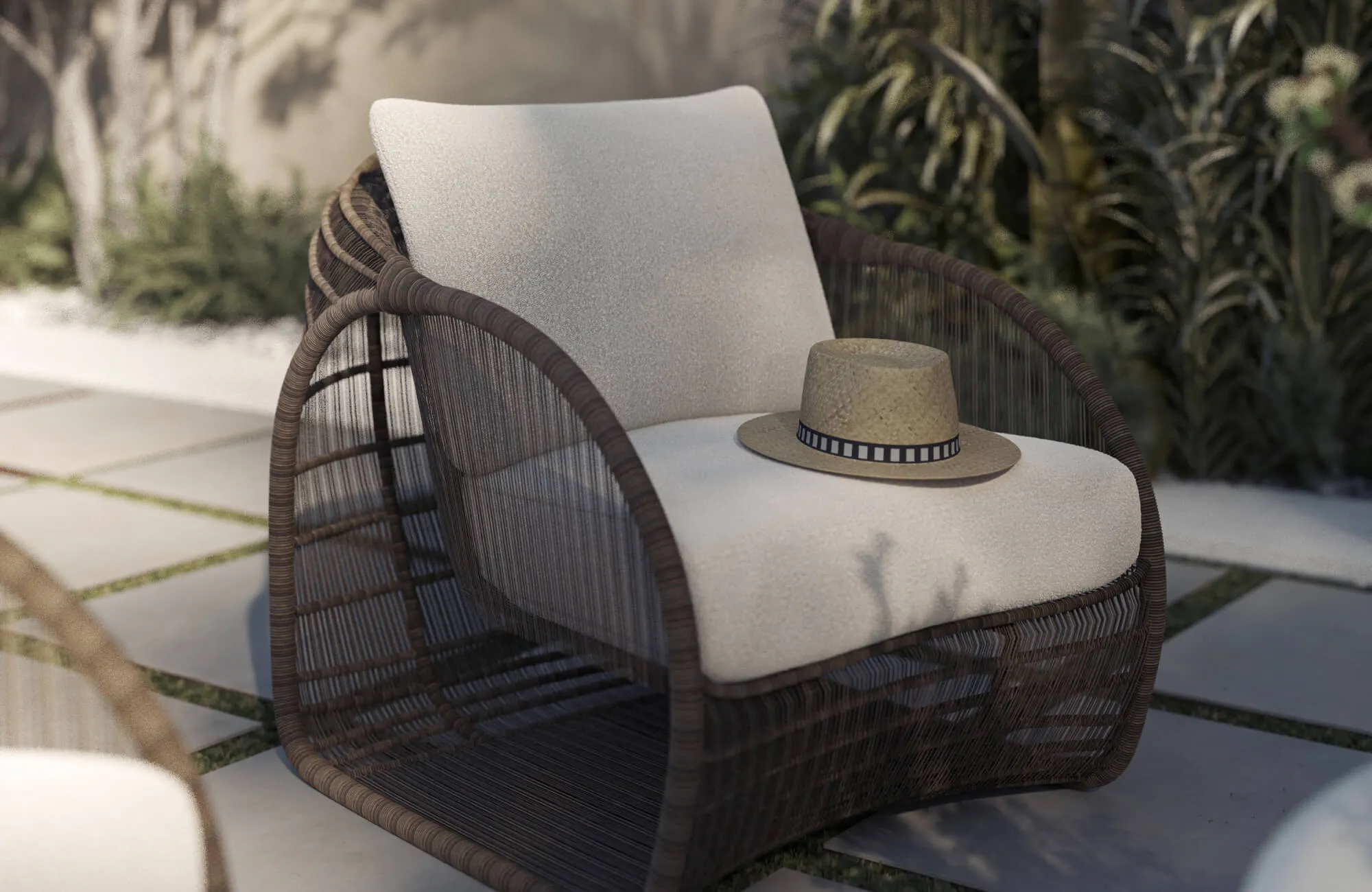 Resting on a woven outdoor chair, a cream cushion softens the seat while a straw hat adds a relaxed touch, highlighting how cushions improve comfort in outdoor furniture.