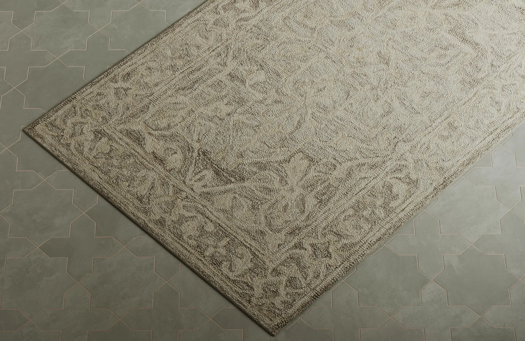 Close-up of a neutral floral rug with detailed woven motifs styled against patterned green tile flooring.