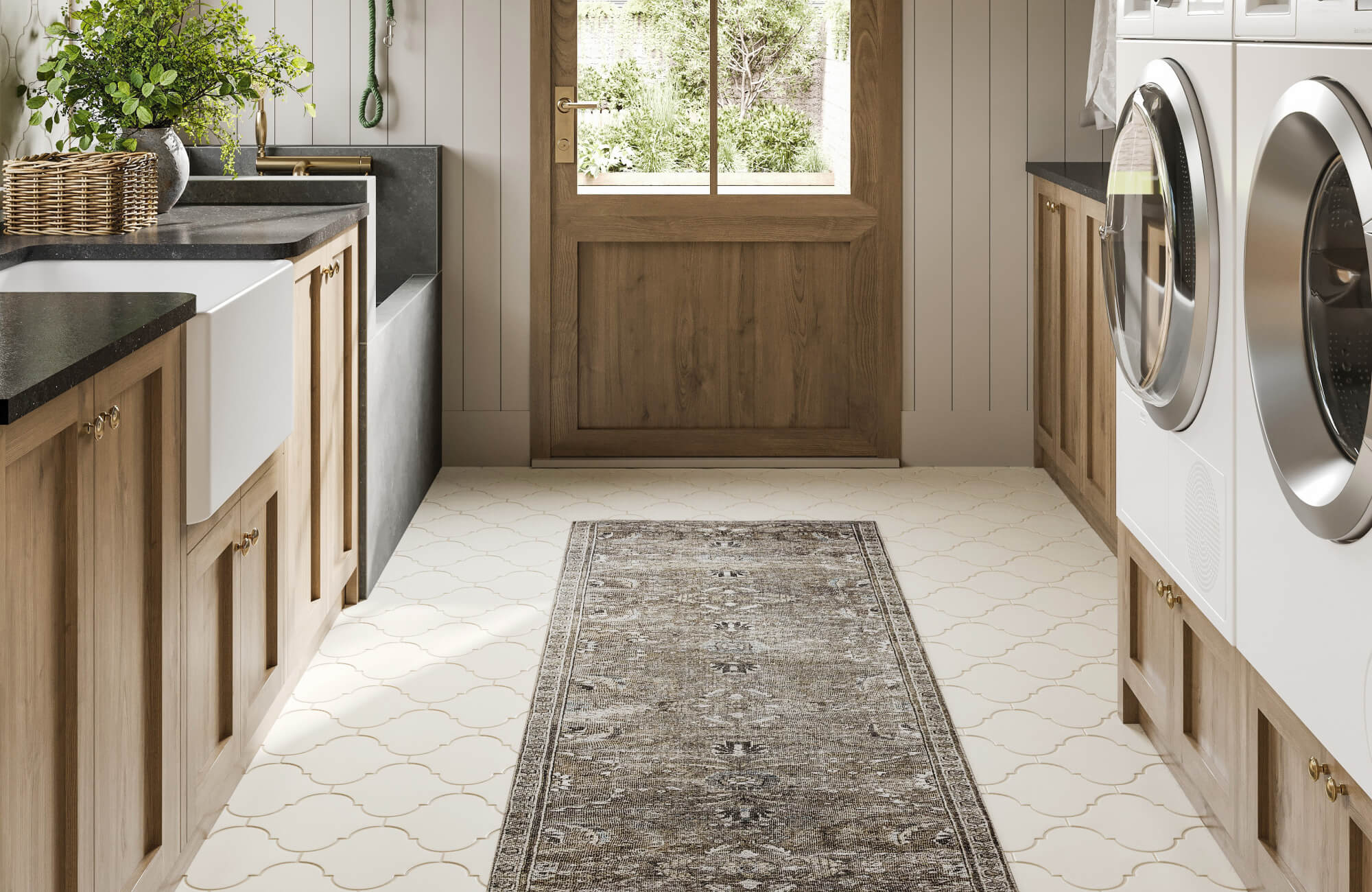 Laundry room with wood cabinets, farmhouse sink, and patterned runner rug styled on cream tile flooring.