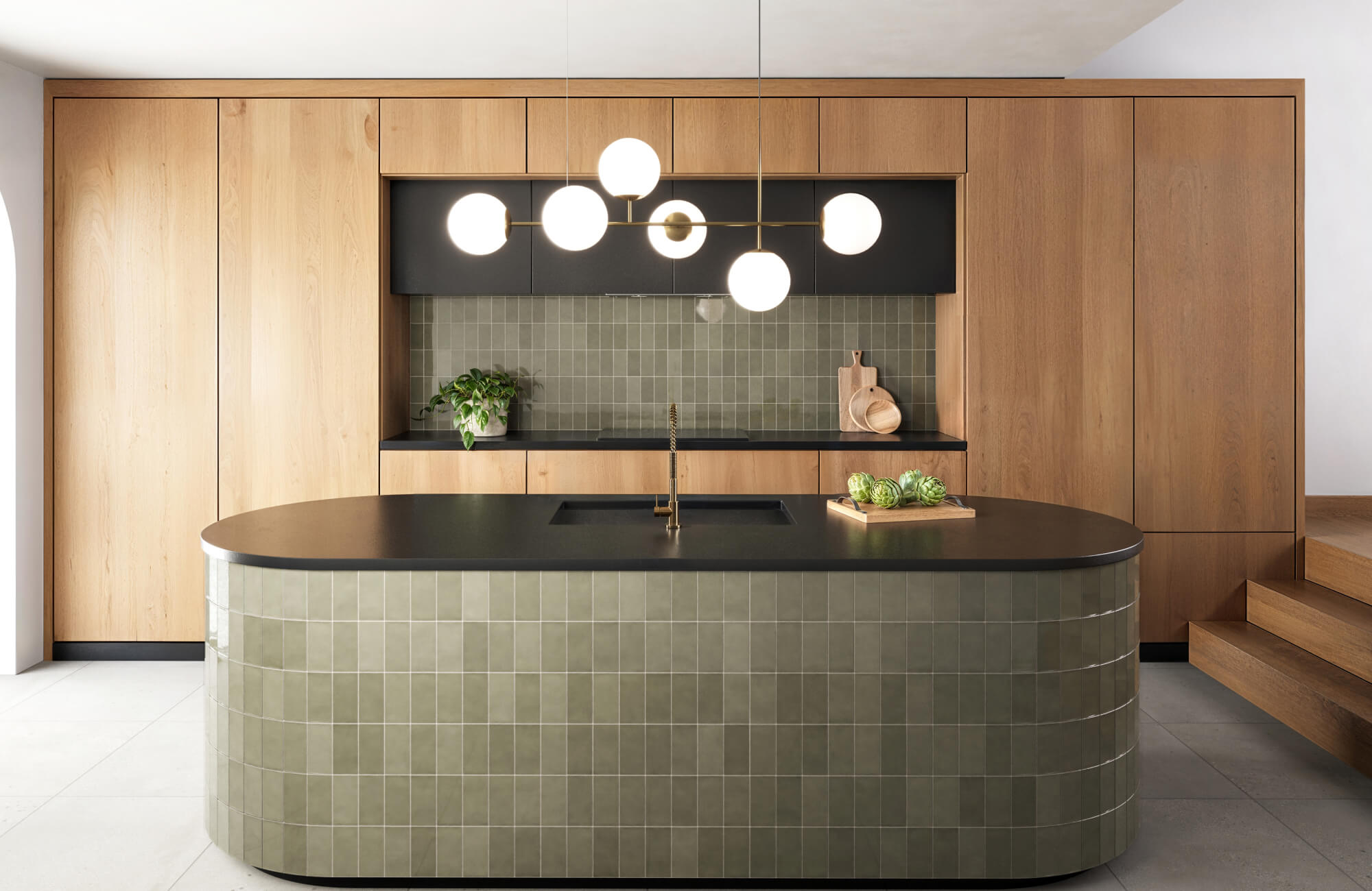 Olive green square tile backsplash and island surround in a modern kitchen with black counters, wood cabinetry, and globe pendant lighting.