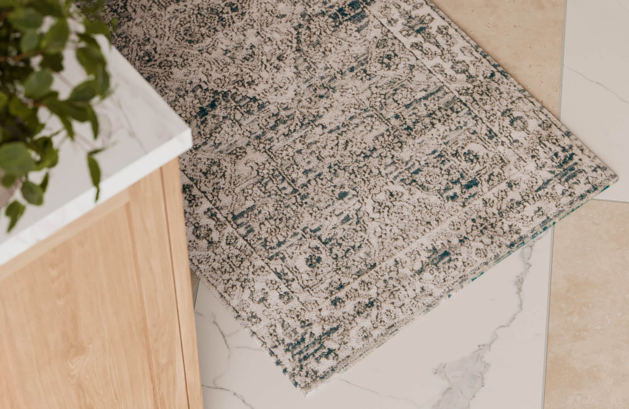 Decorative runner rug with intricate design adding texture and comfort to a kitchen floor near light wood cabinetry.