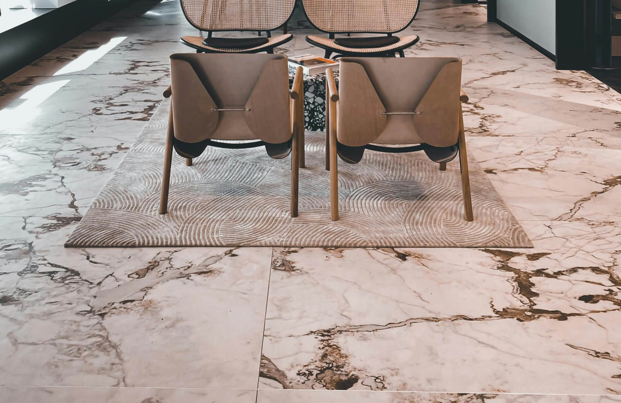 null Modern seating area on a textured rug, surrounded by luxurious marble flooring with bold, natural veining.