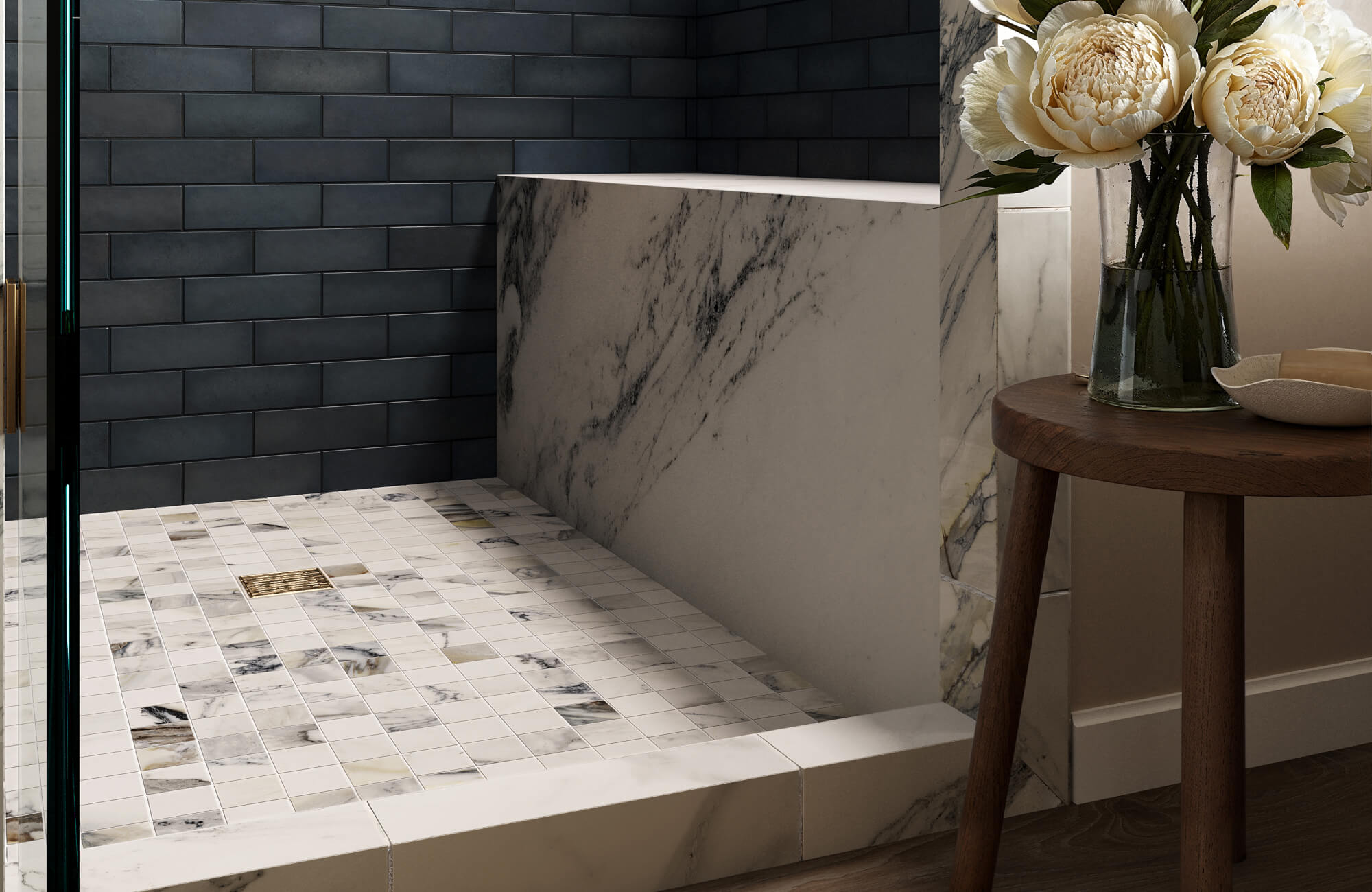 Marble look mosaic tile shower floor in soft white and gray tones, paired with dark wall tiles and marble surfaces for a refined, slip-friendly design.