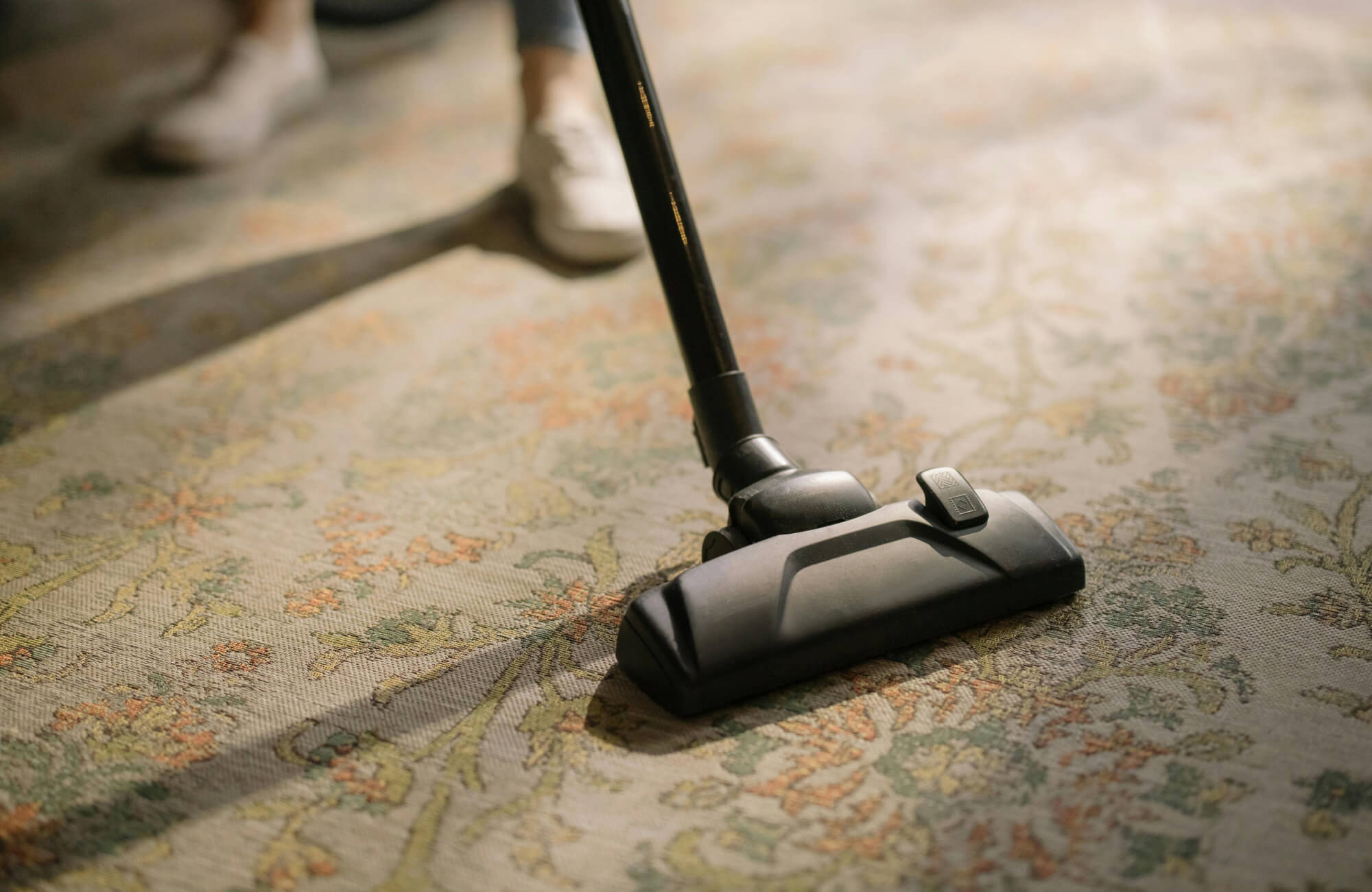 Vacuum cleaner in use on a floral-patterned polypropylene rug, highlighting ease of maintenance and everyday durability.