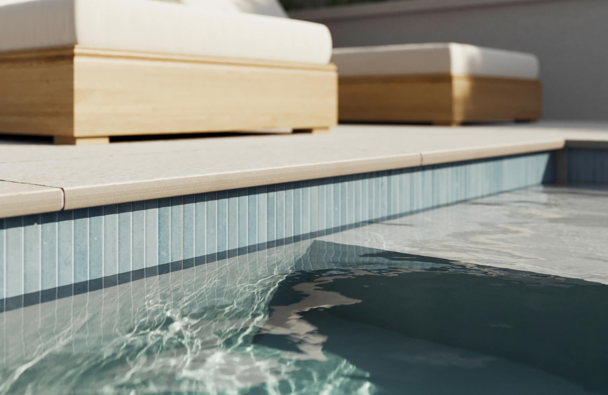 Porcelain pavers line the pool’s edge with precise cuts and smooth coping detail, pairing elegance with slip-resistant functionality