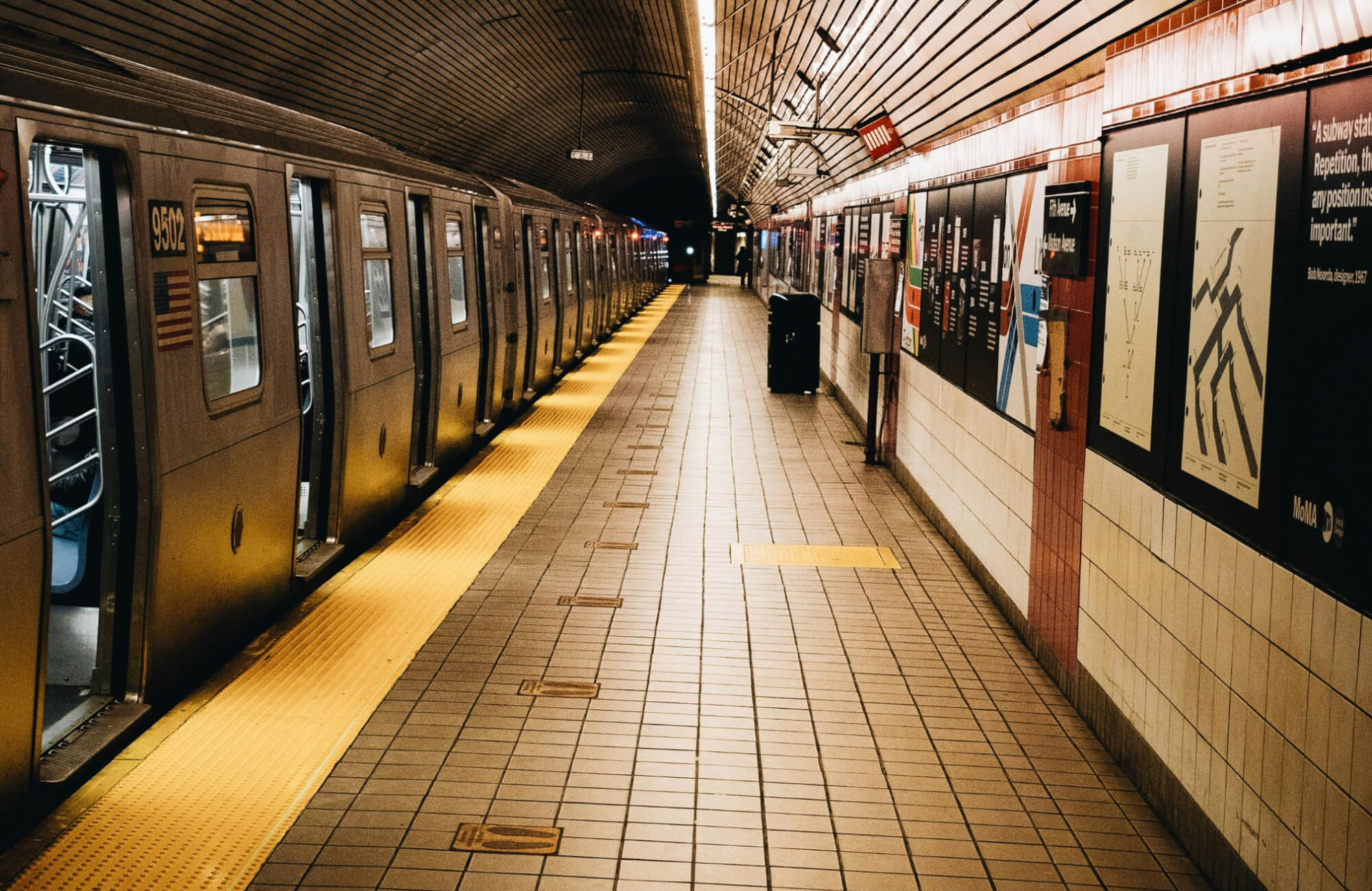 null Subway station, lined with classic beige subway tiles and bold red accents, complements the sleek, modern train platform design.