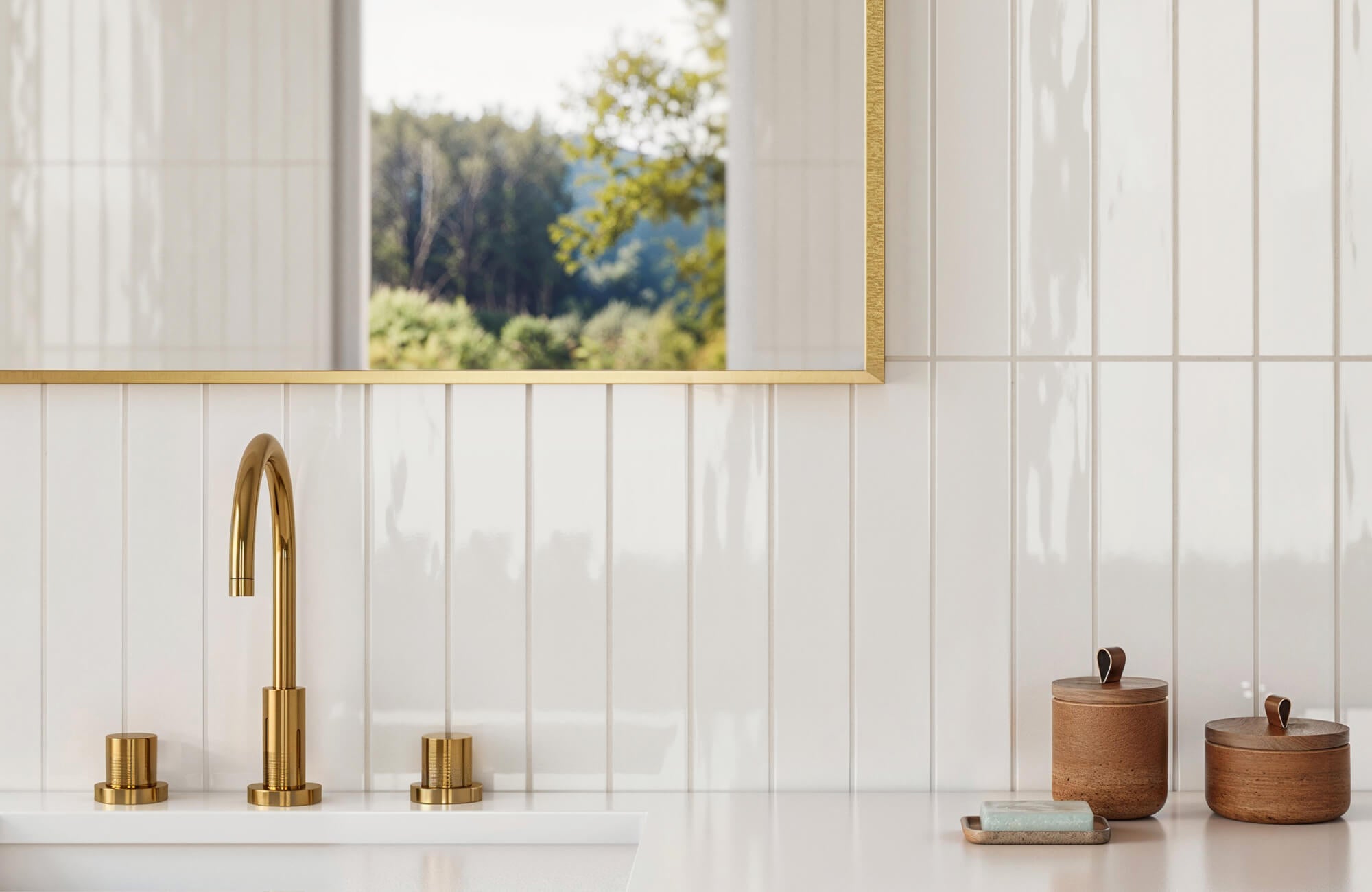 null Elegant bathroom with glossy white vertical subway tiles, a brass faucet, and wooden accessories, complemented by a gold-framed mirror reflecting greenery.