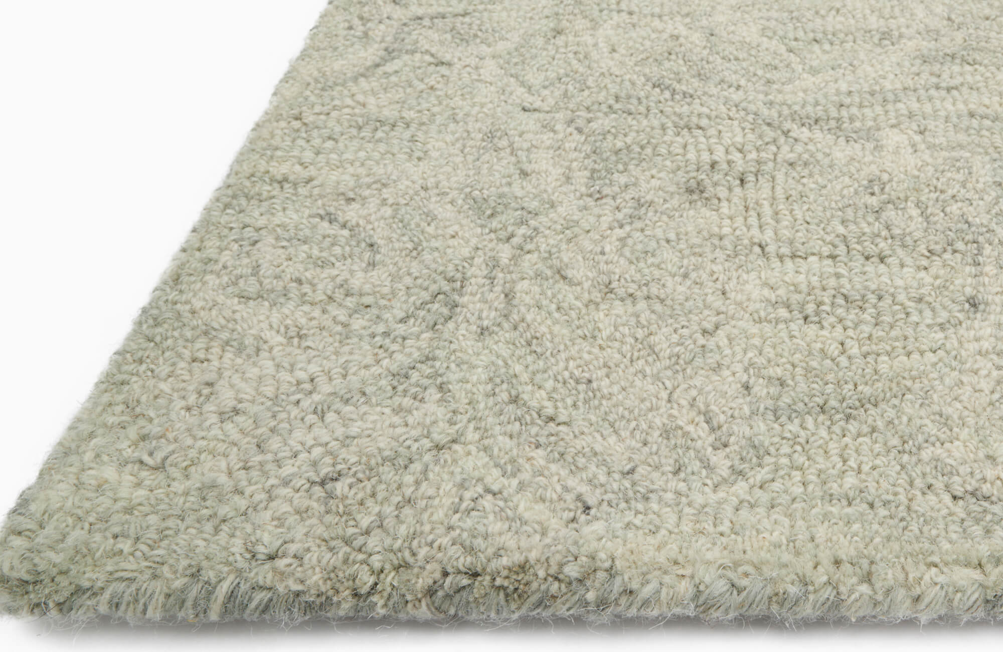 Close-up of a textured wool rug in soft neutral tones, showcasing its looped weave and subtle pattern detail.