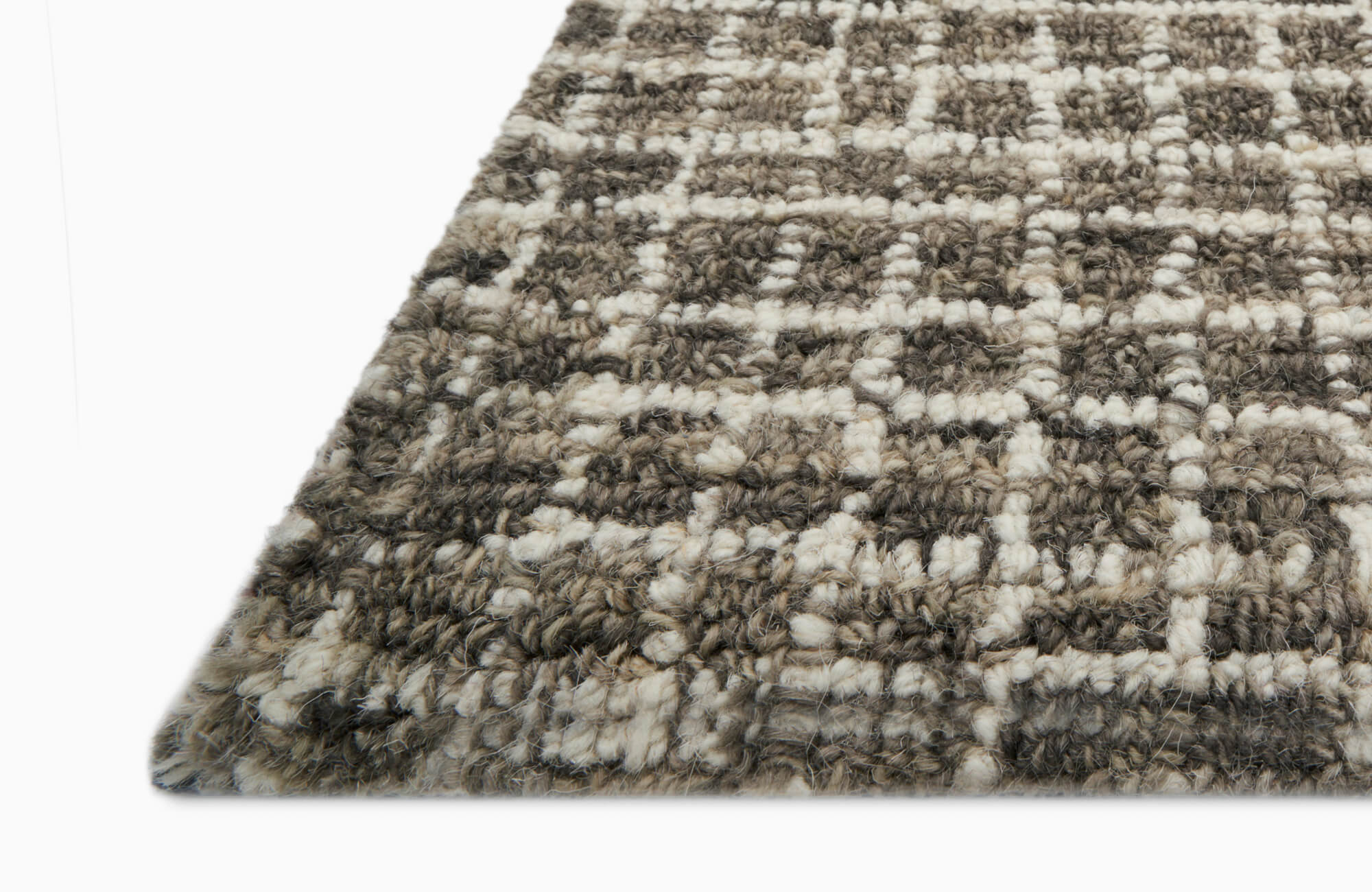 A soft gray and white wool rug detail showing its thick texture and subtle pattern that brings warmth to any room.