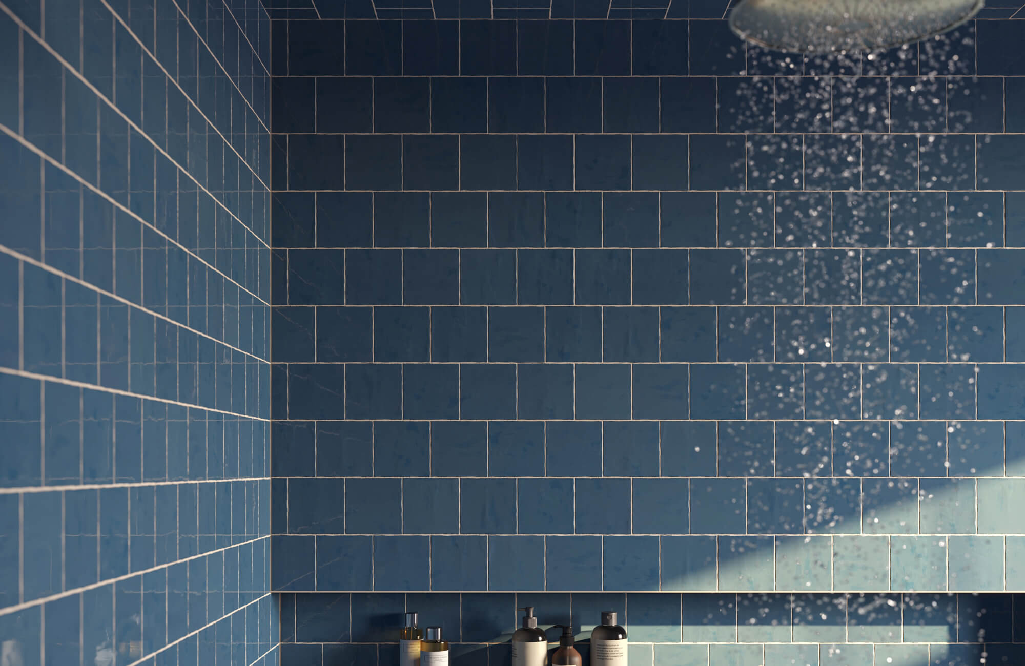 null This bold bathroom design trend highlights deep blue subway tile shower walls with crisp grout lines, a built-in niche with minimal bath accessories, and a rainfall showerhead for an added contemporary character.