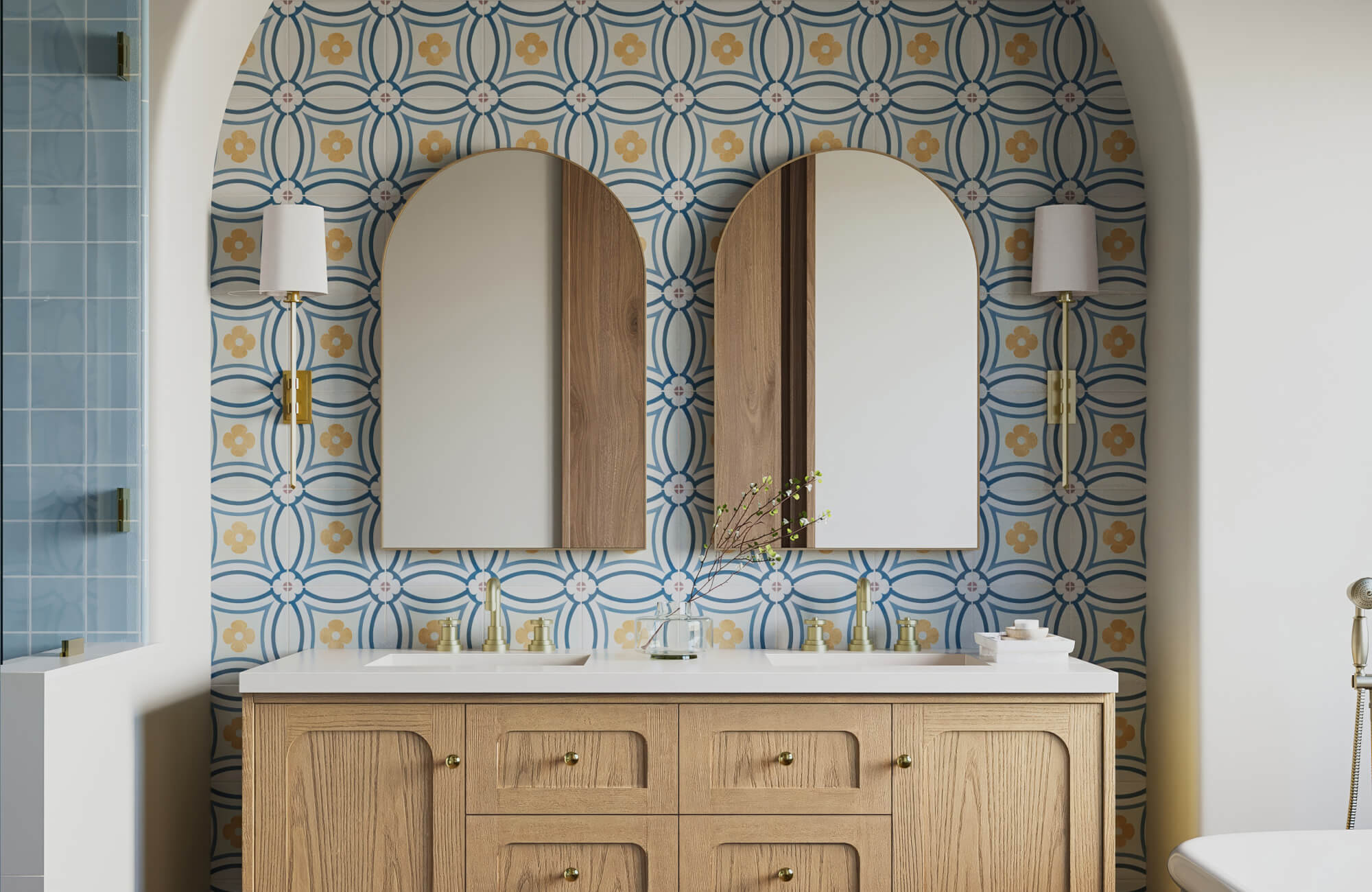 null Chic bathroom vanity lighting with slim brass sconces and white shades flanking arched mirrors, accentuating the bold patterned tile backsplash and warm wood cabinetry.