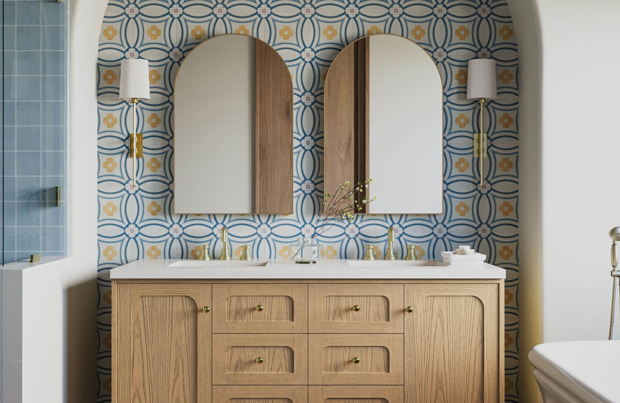 null Vibrant bathroom double vanity featuring a light wood cabinet with arched panels, twin mirrors, and gold fixtures, set against a bold blue and mustard geometric tile backsplash that adds artistic flair and warmth.