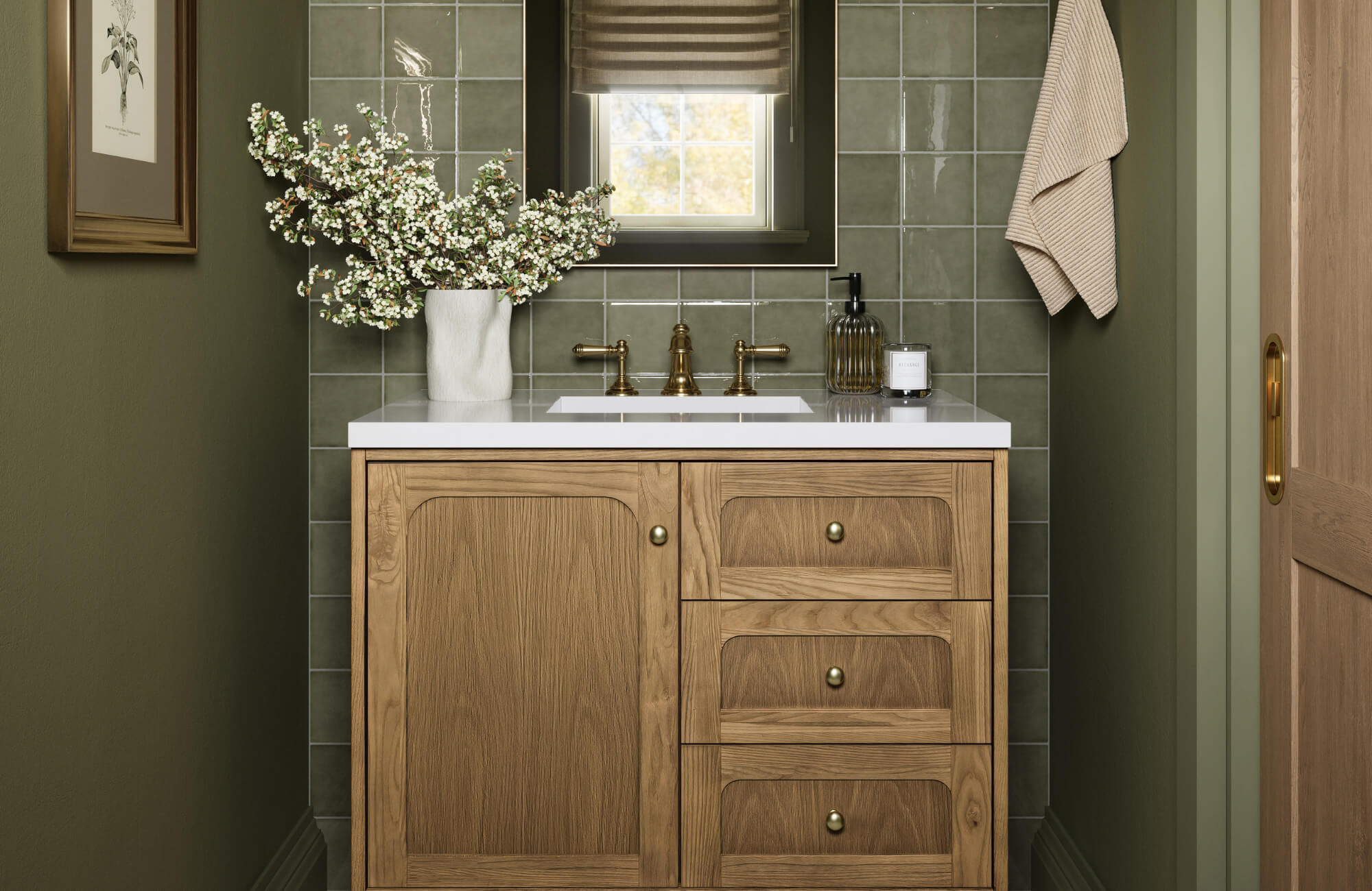 Bathroom with a natural wood vanity, white countertop, brass fixtures, green tiled backsplash, and decorative vase with flowers.