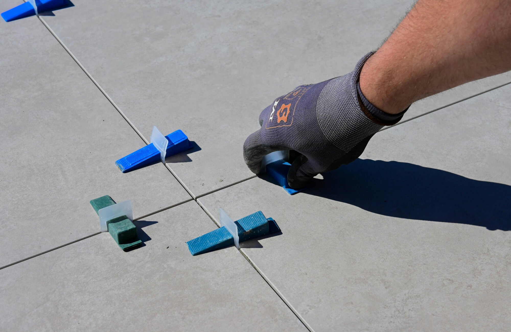 null Close-up of porcelain paver installation, showing precision leveling clips and spacers on large-format tiles for a seamless, even layout