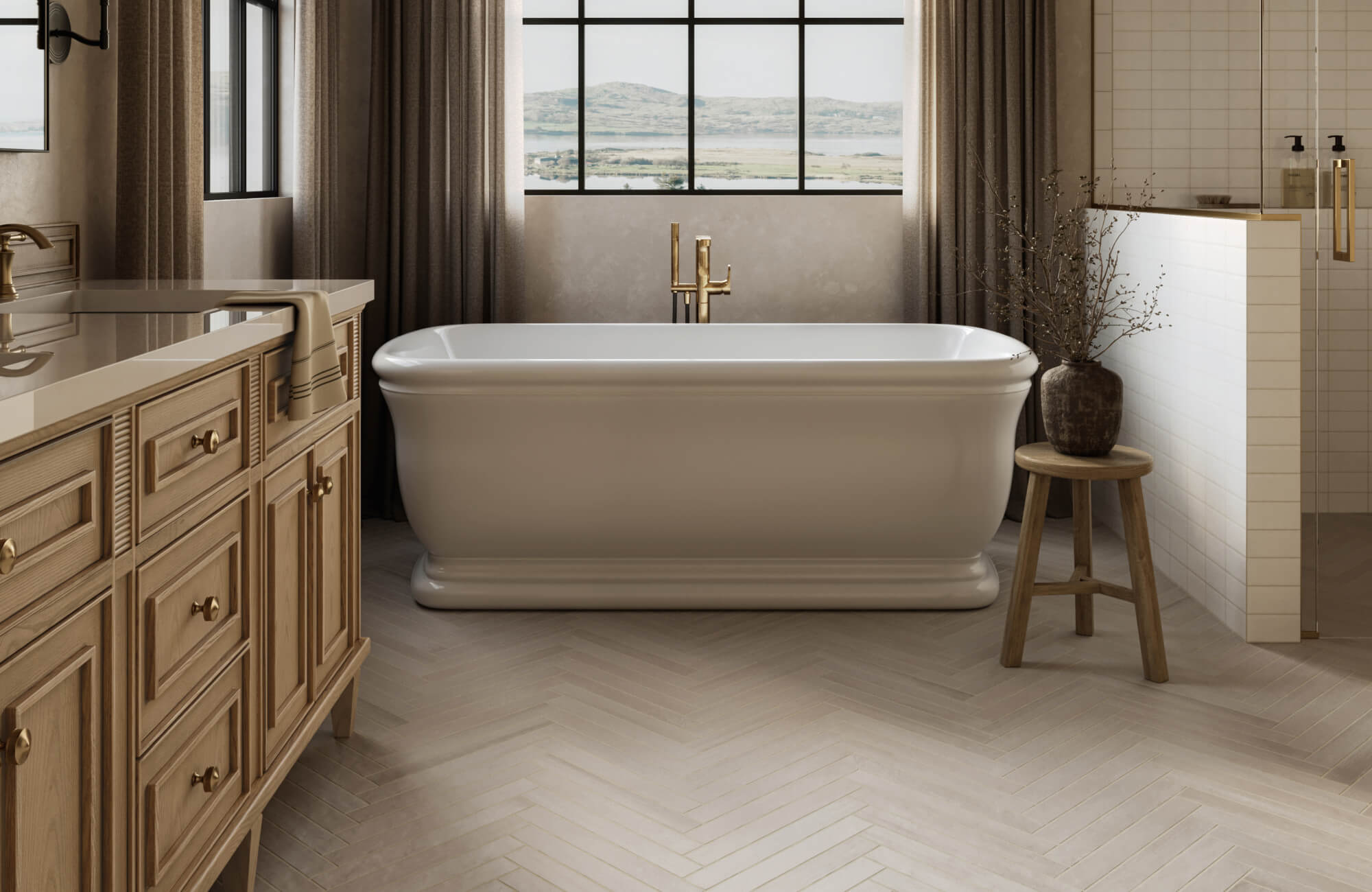 Bright bathroom with a freestanding bathtub, brass fixtures, and cream subway tile walls, complemented by a light herringbone tile floor and natural wood vanity.