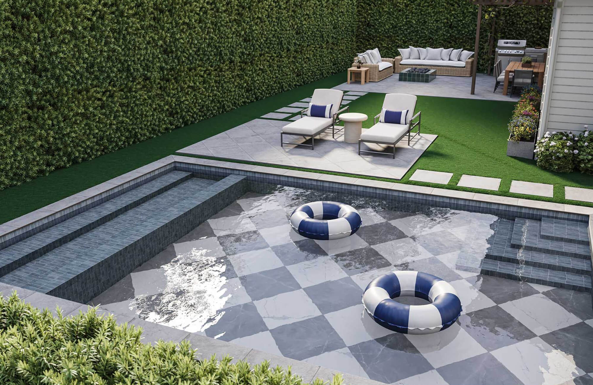 null Backyard pool with gray checkerboard tile, floating pool rings, lounge chairs, stepping stones, and surrounding greenery.