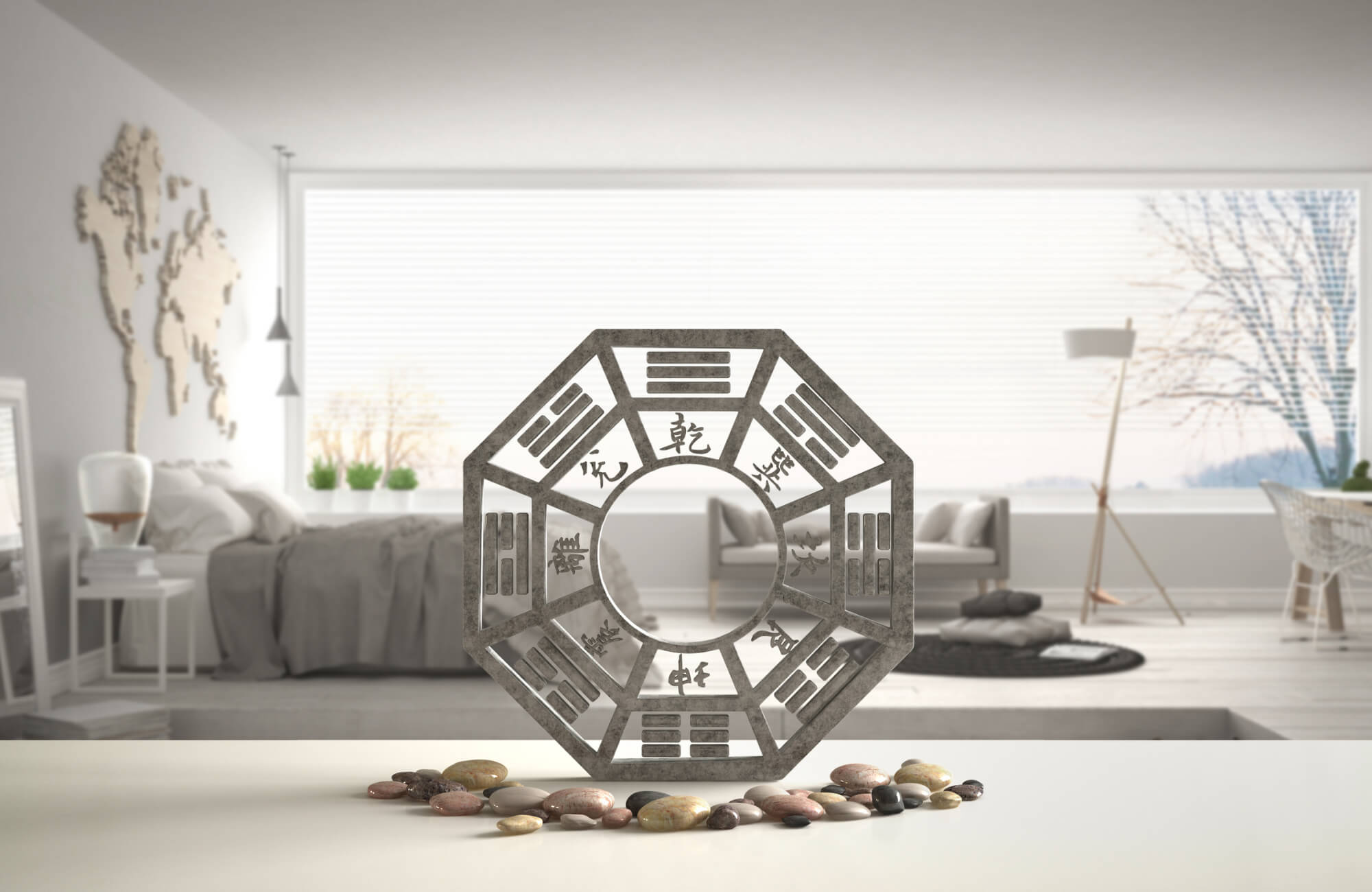 Feng Shui Bagua mirror decor on a white surface with smooth stones, set in a modern, light-filled living space with minimalist design.