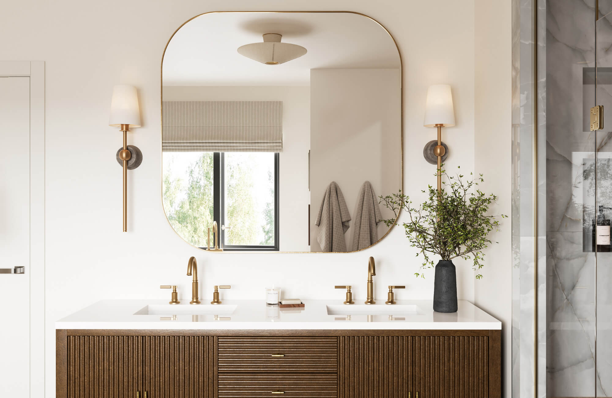 Modern bathroom with a wide, rounded mirror, double sink vanity with brass fixtures, wall sconces, and natural accents in a serene palette.