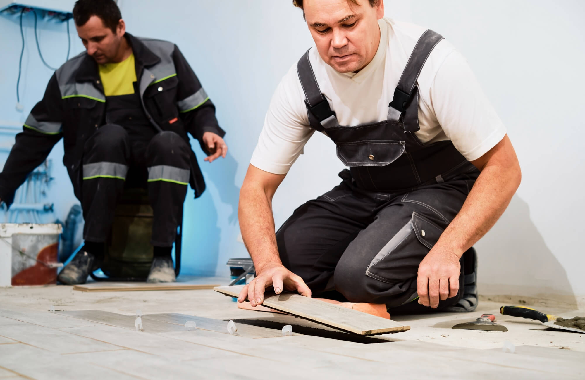 Professional flooring installation with precise tile alignment and spacing on a prepared subfloor.