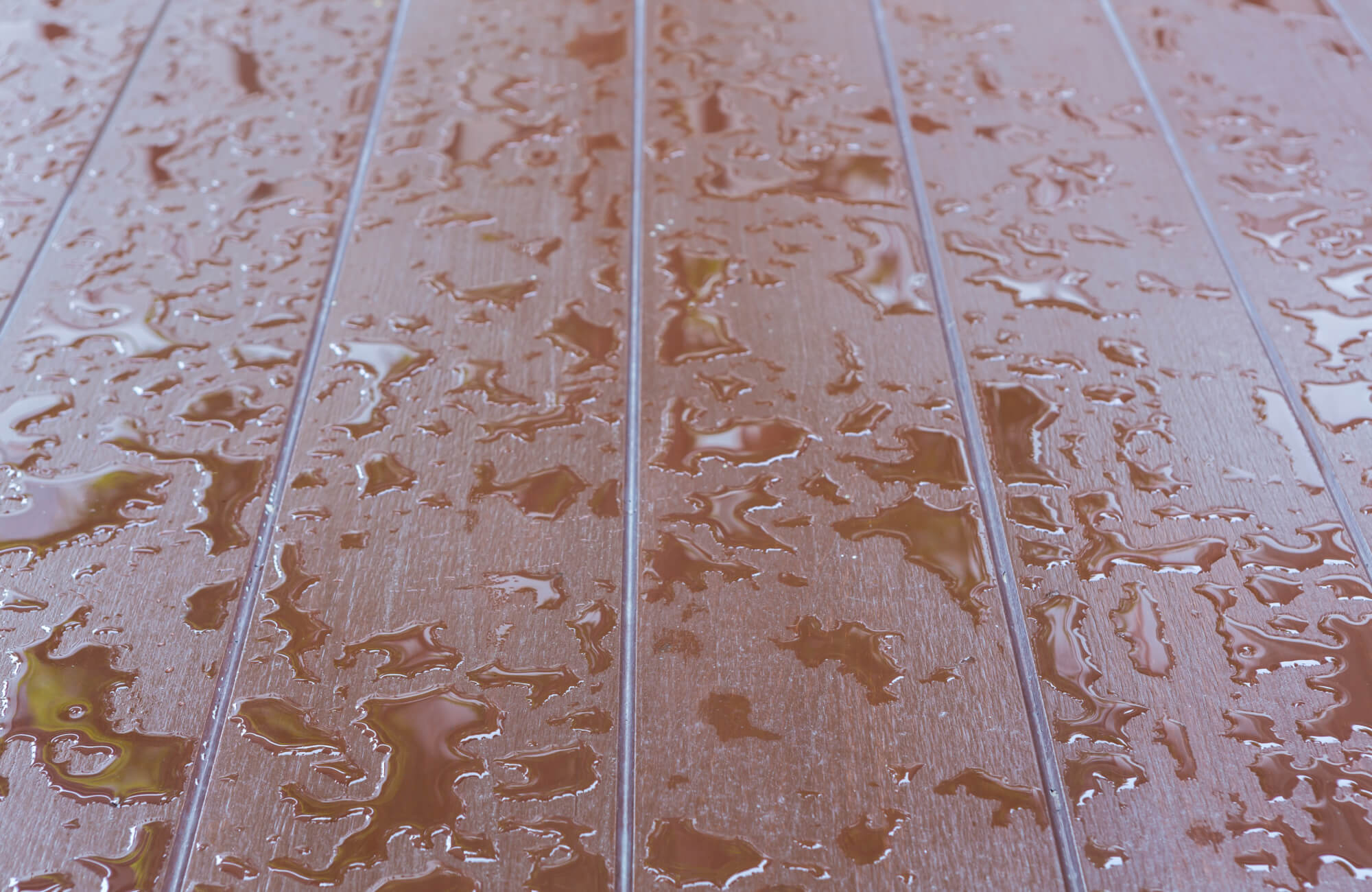 null Water droplets scattered across wood look porcelain tiles, highlighting their textured, water-resistant surface ideal for outdoor or wet areas.