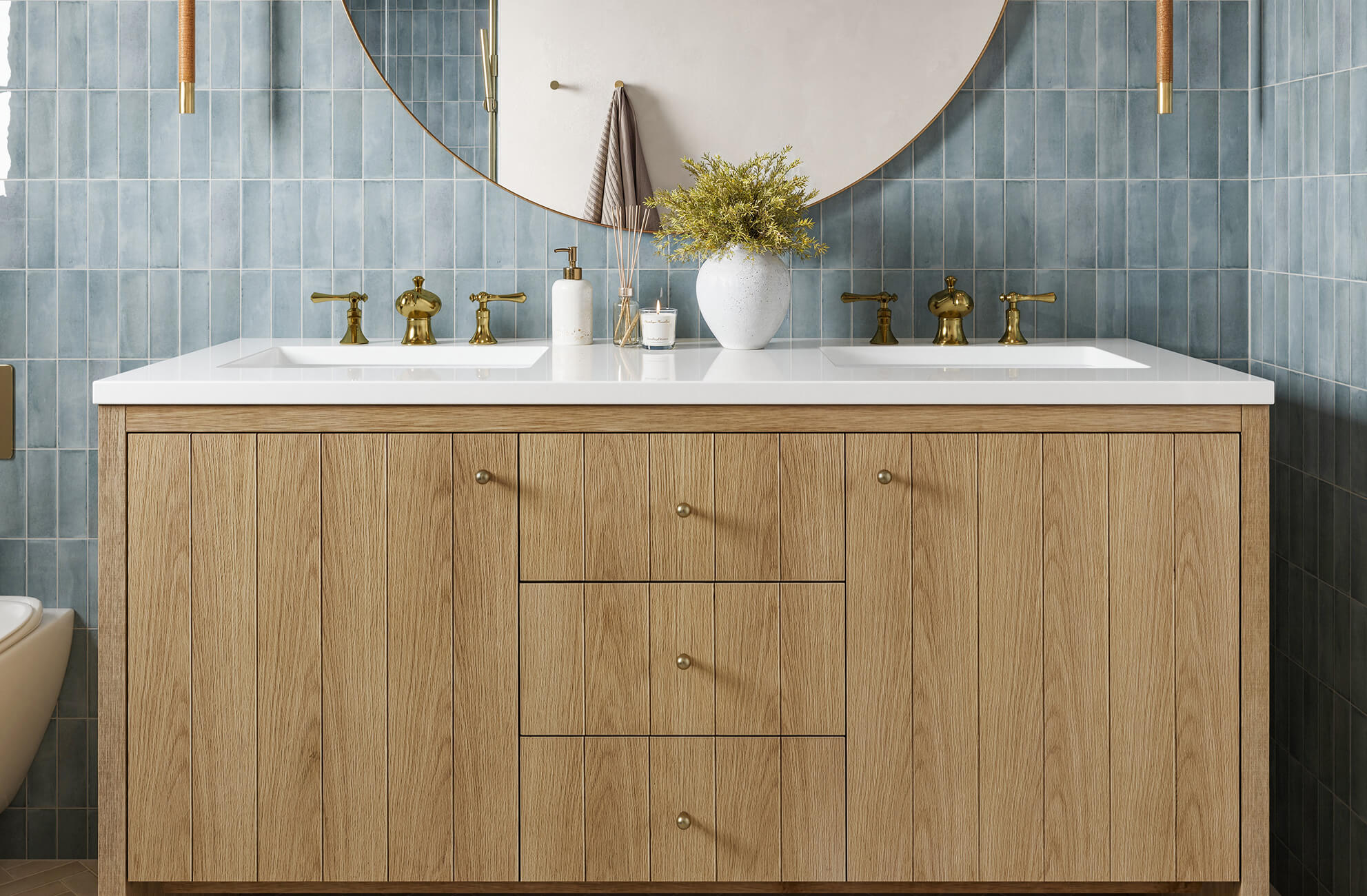 null Vertical oak vanity with brass fixtures set against glossy blue rectangular wall tiles and a large round mirror.