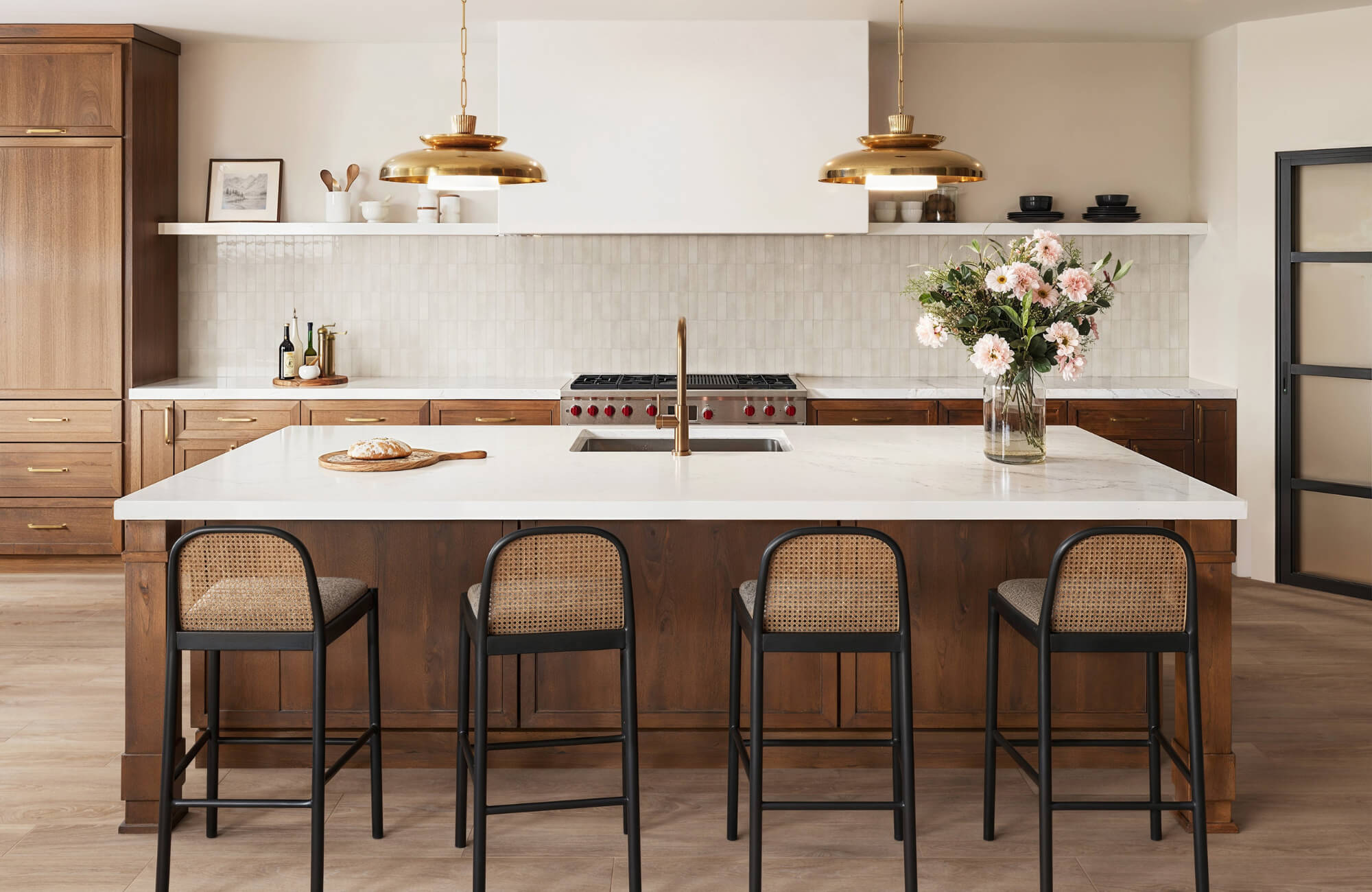 null Contemporary kitchen with wood cabinets, white countertops, brass accents, and a zellige tile backsplash behind the range.