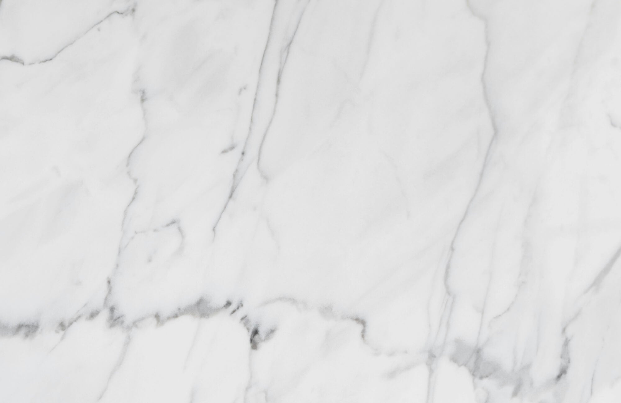 null Close-up of Carrara marble surface showing soft gray veining on a white background, highlighting the natural elegance of marble tile.