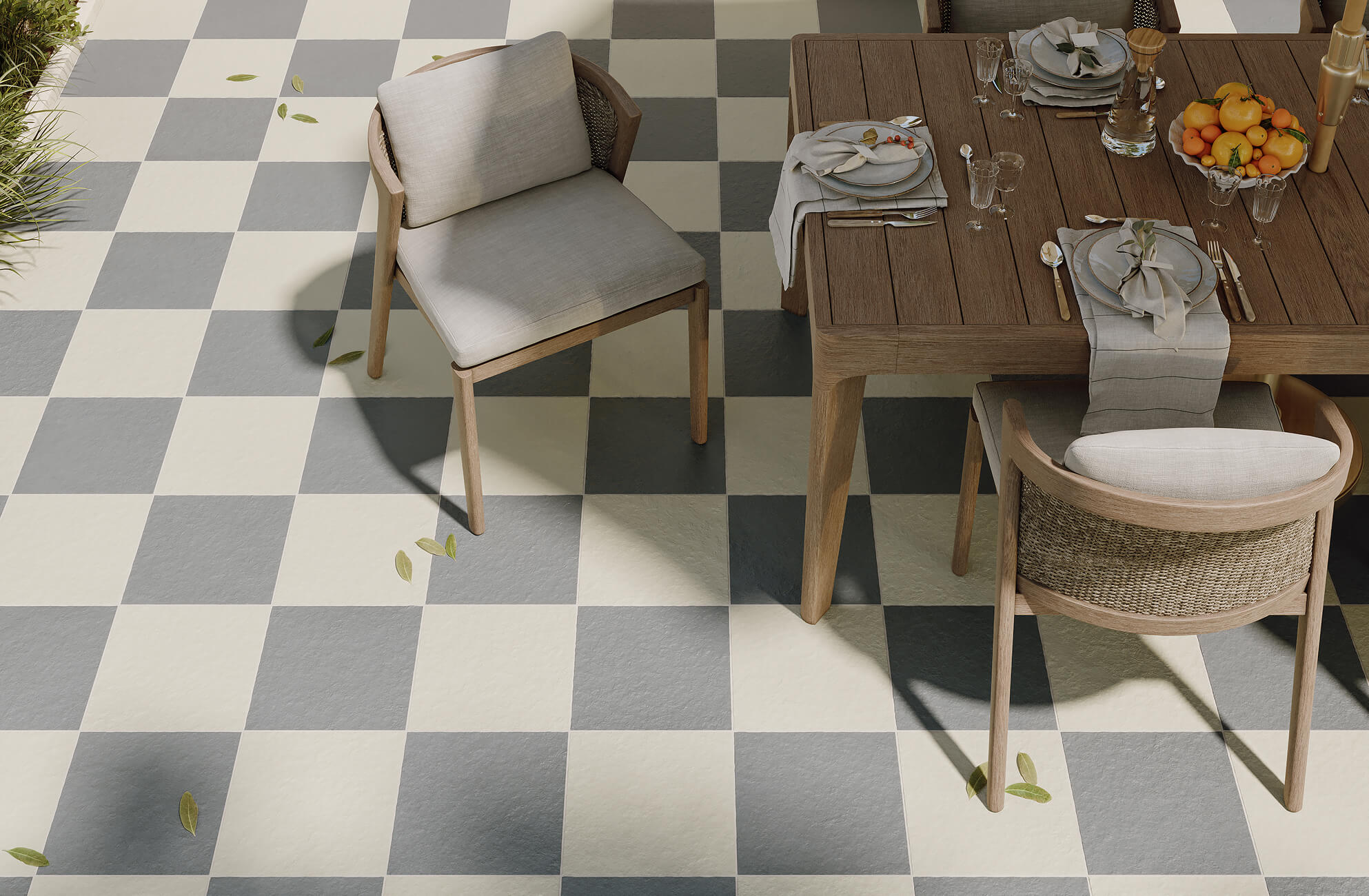 null Stylish outdoor dining area with grey and cream checkerboard tiles and a wood table set for a fresh, elegant meal.