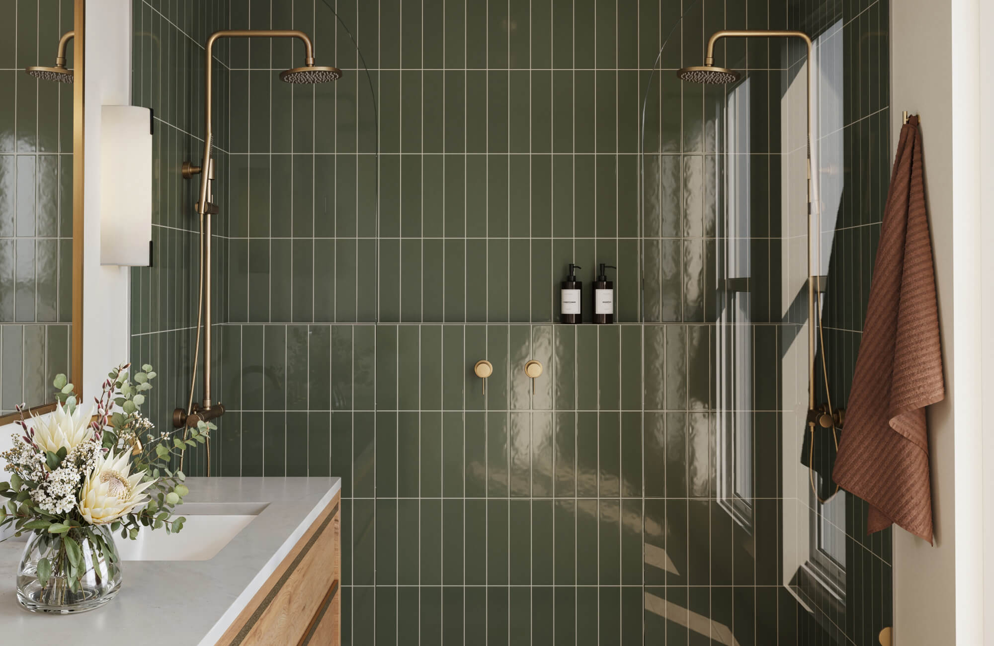 Modern dual-shower space featuring sage green glossy subway tiles and brushed gold fixtures for a polished look.