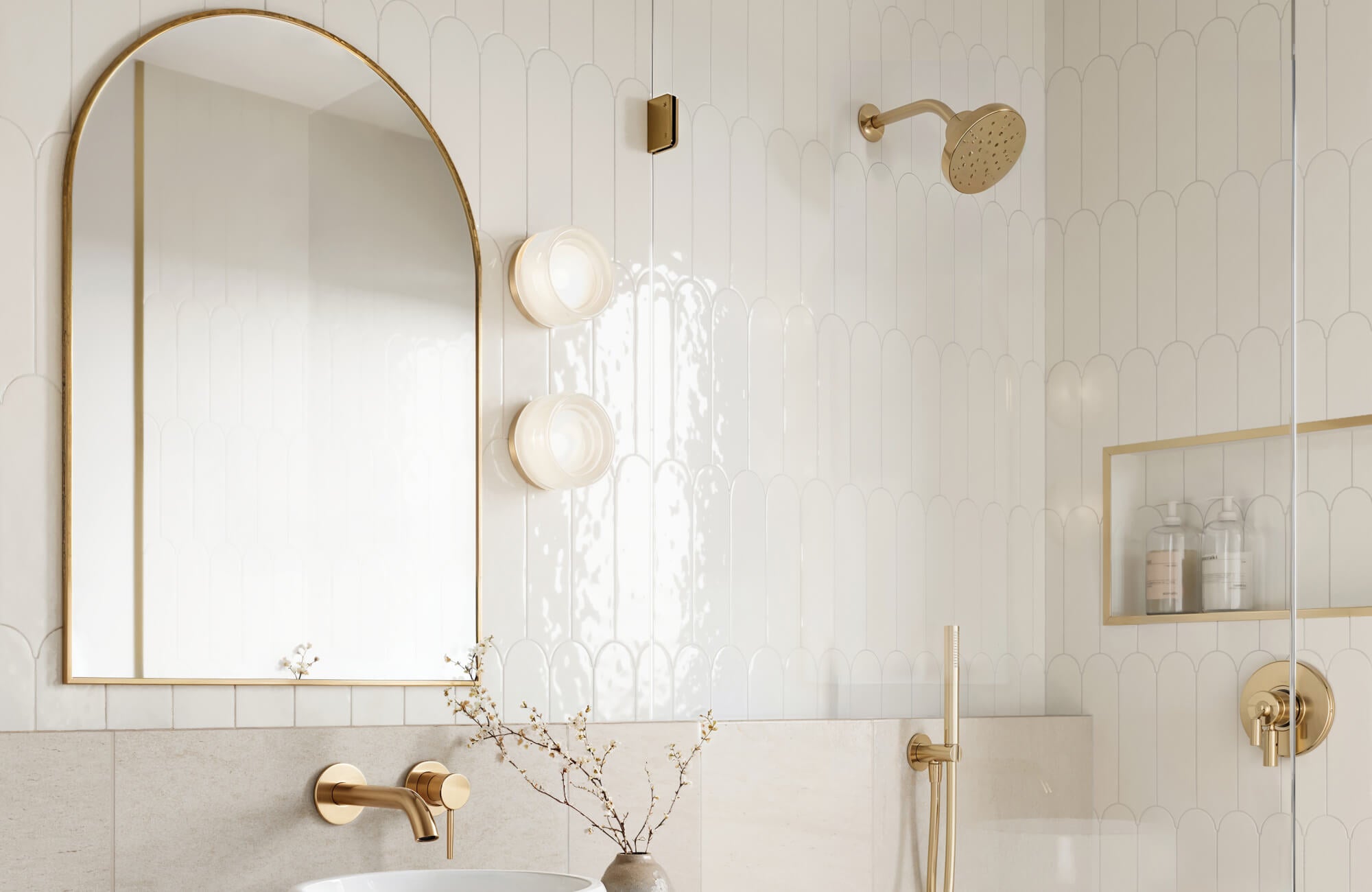 Elegant bathroom tile design featuring glossy white scallop bathroom wall tiles in a vertical layout, paired with brushed gold fixtures, arched mirror, and built-in niche for a clean modern bathroom aesthetic.