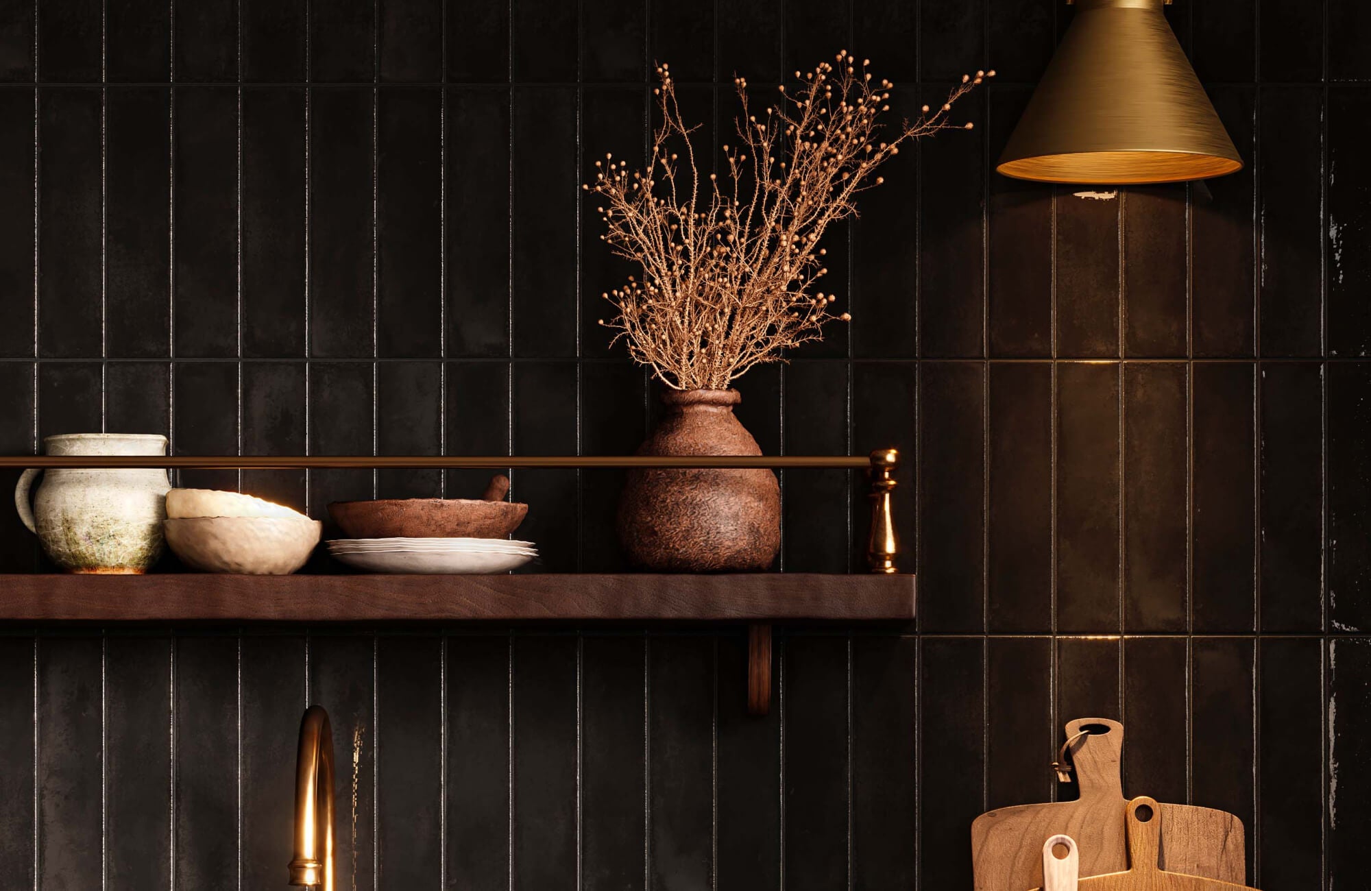 null A textured earthenware vessel with dried branches is arranged among stoneware, wood, metal, and dark tile surfaces in a richly layered kitchen setting.