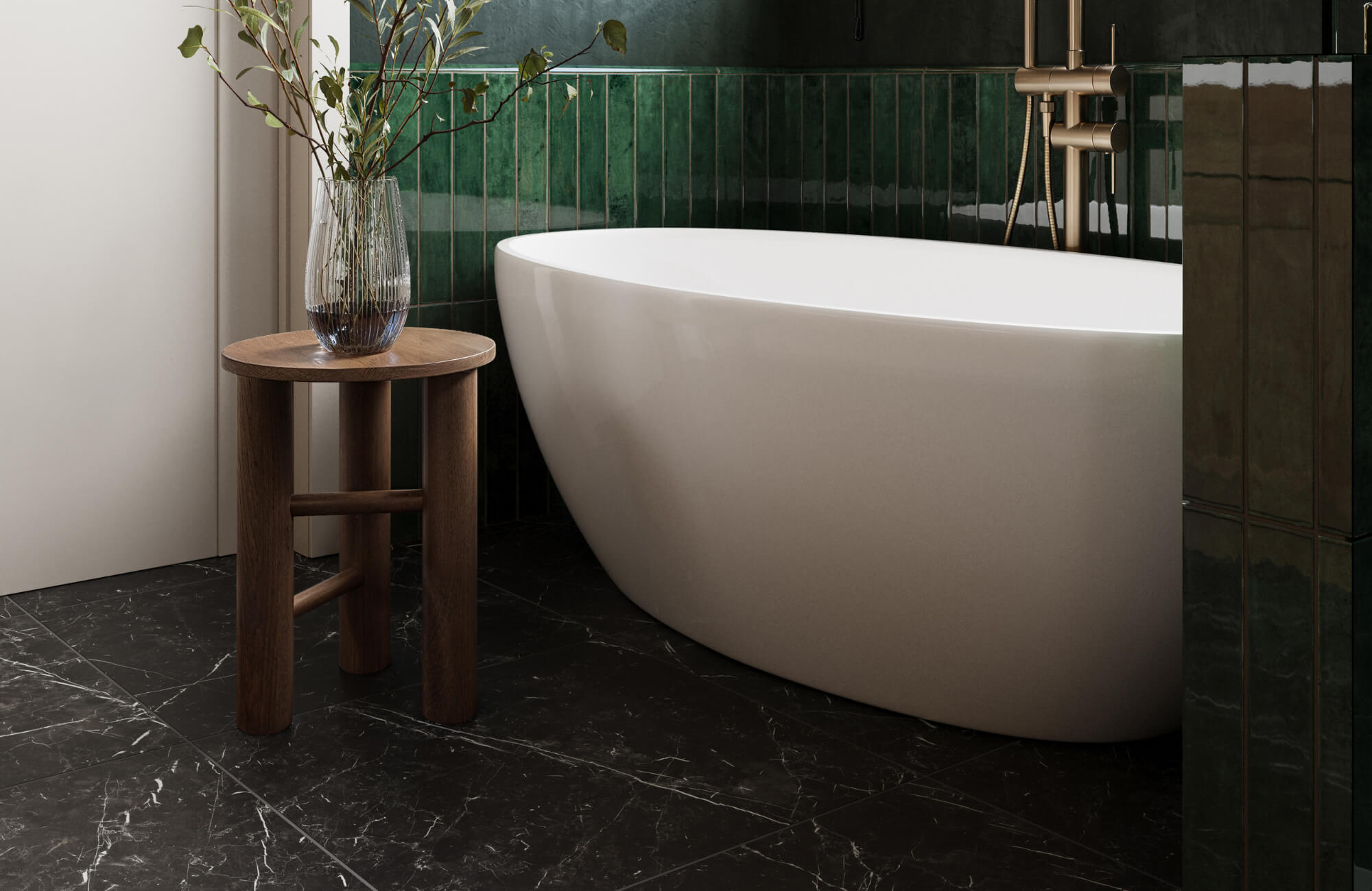 Elegant bathroom with black marble floor tiles, a white freestanding tub, green vertical wall tiles, and a wooden stool with a glass vase.