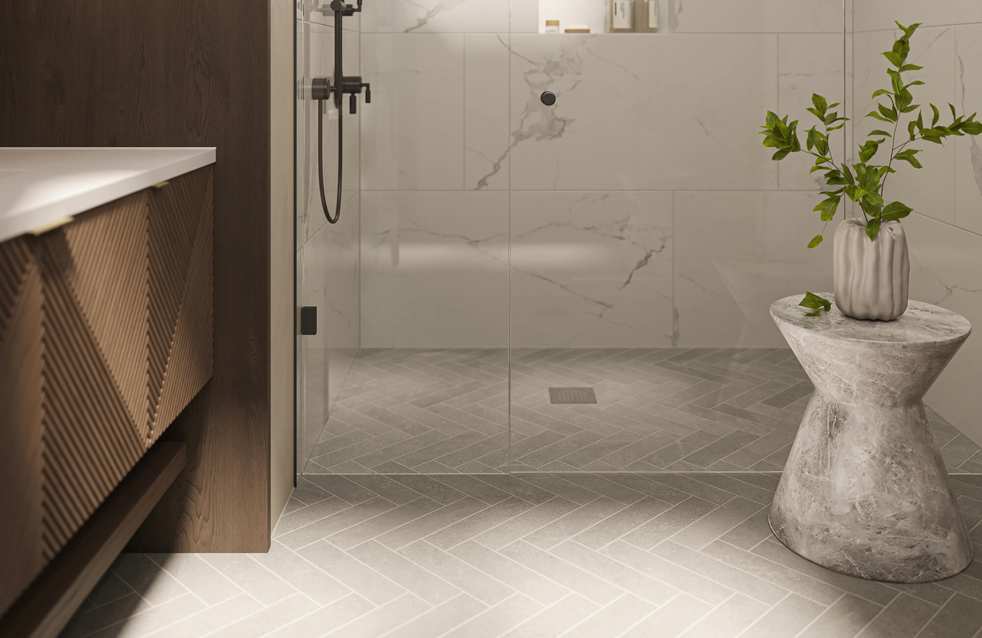 Modern shower with light gray herringbone tile flooring, glass enclosure, wood vanity, and marble-look walls for a clean, elegant finish.