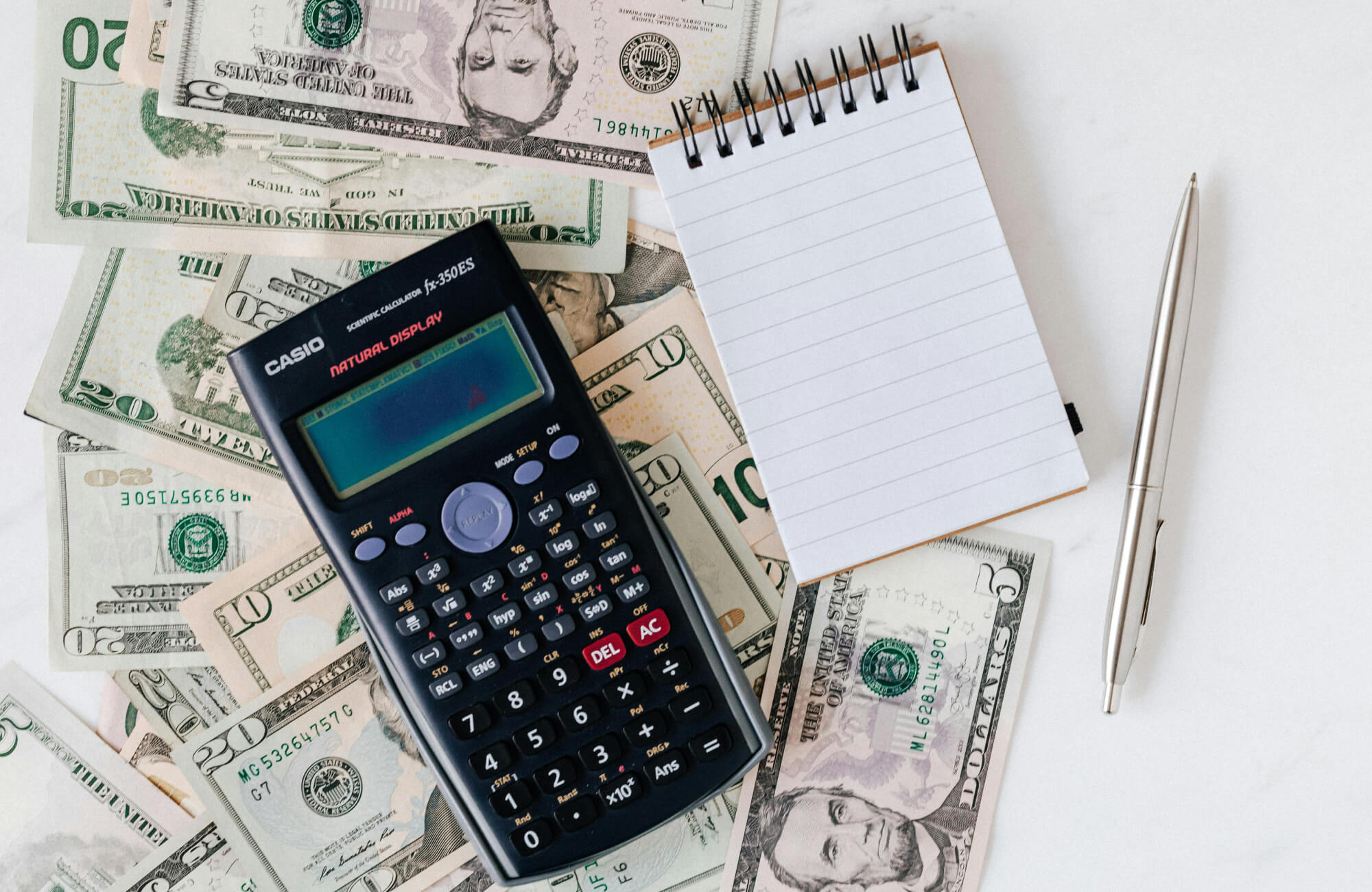 null Calculating long-term savings from LED lighting with a scientific calculator, cash, and a notepad—illustrating return on investment.