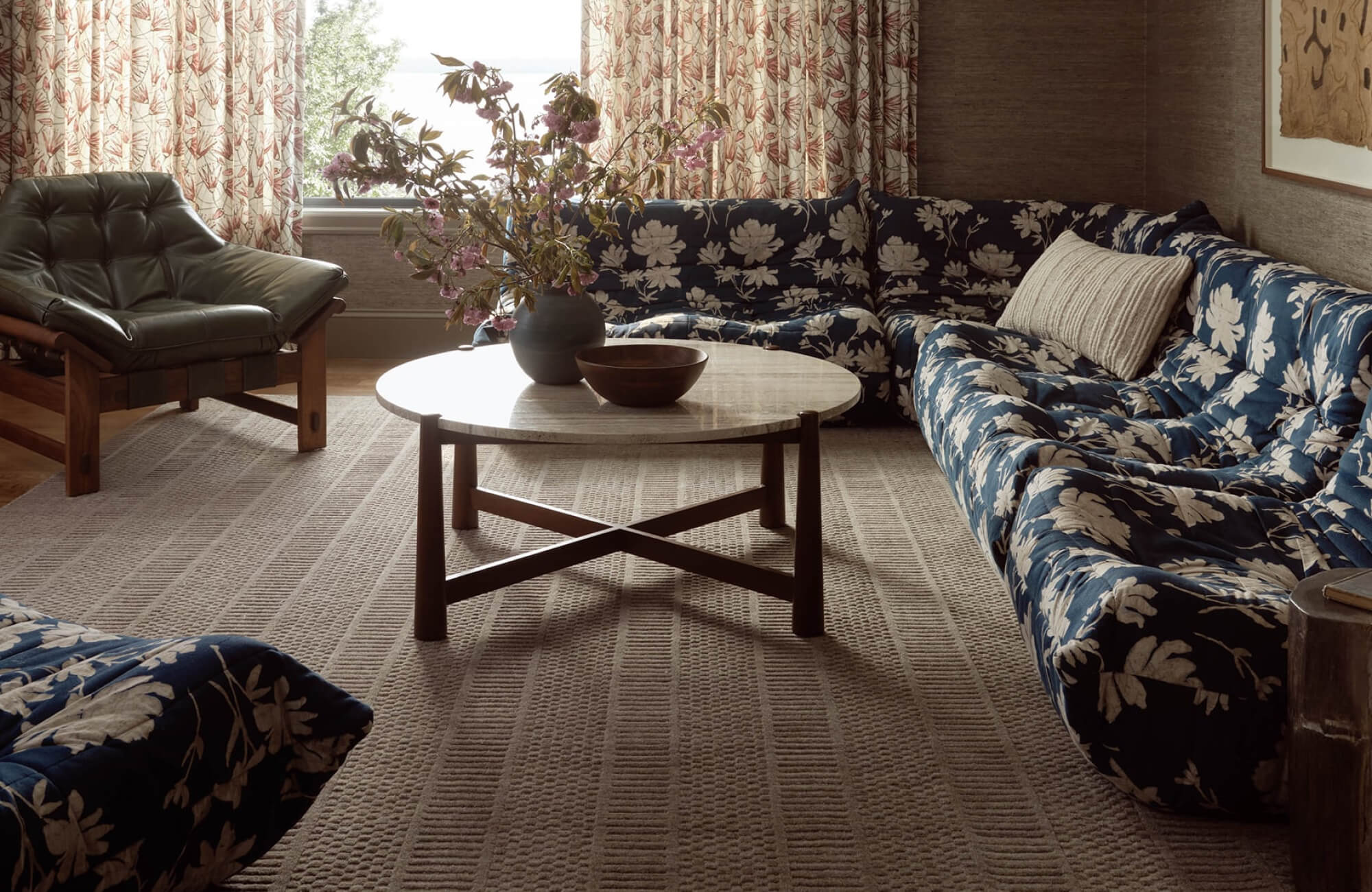 null Cozy eclectic lounge with textured neutral woven rug, subtle grid pattern complementing floral sofa and layered vintage decor.