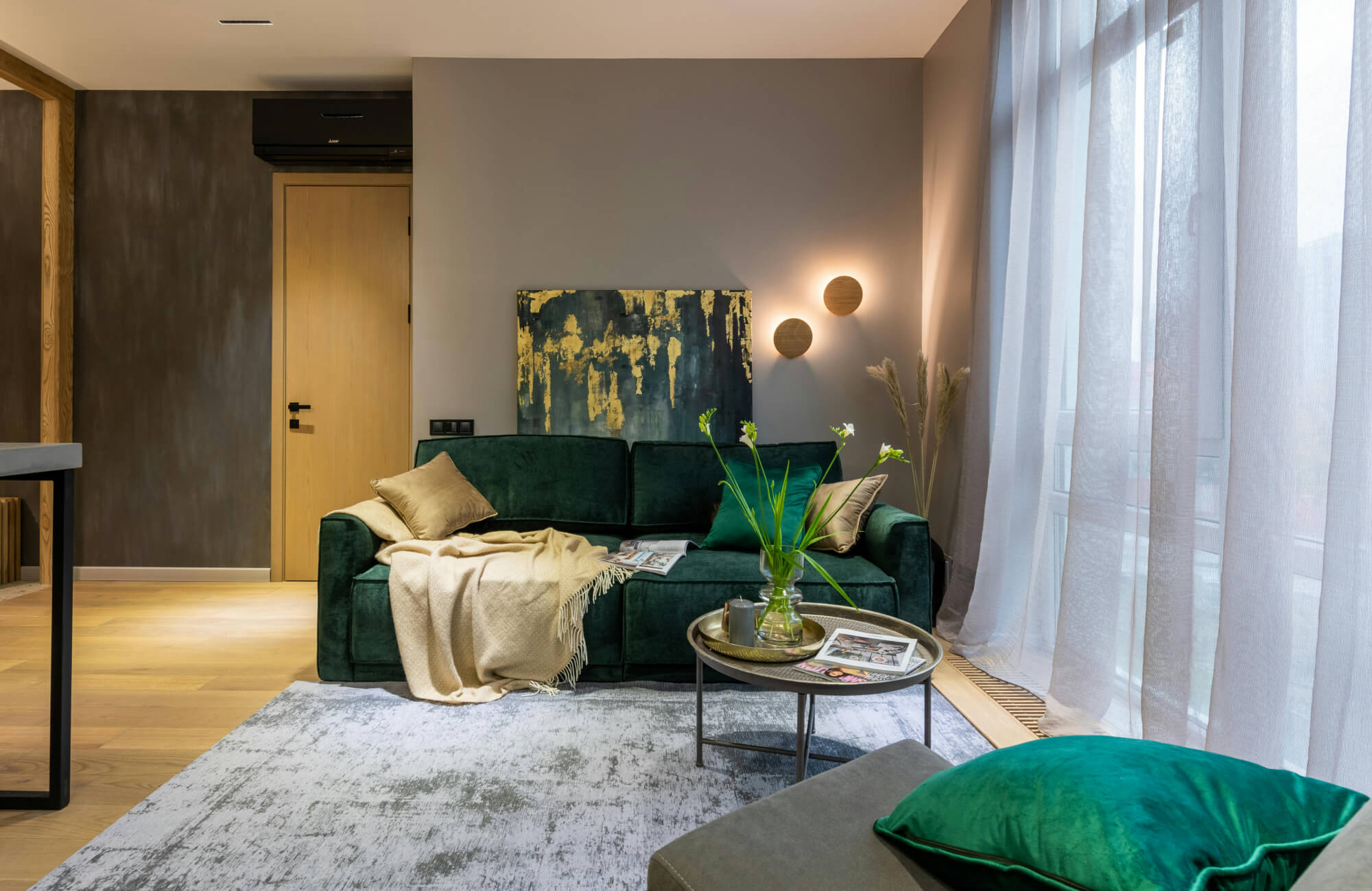 Medium-sized dark artwork above a sofa in a cozy living area, illustrating how smaller scale and heavier tones can make a space feel more confined